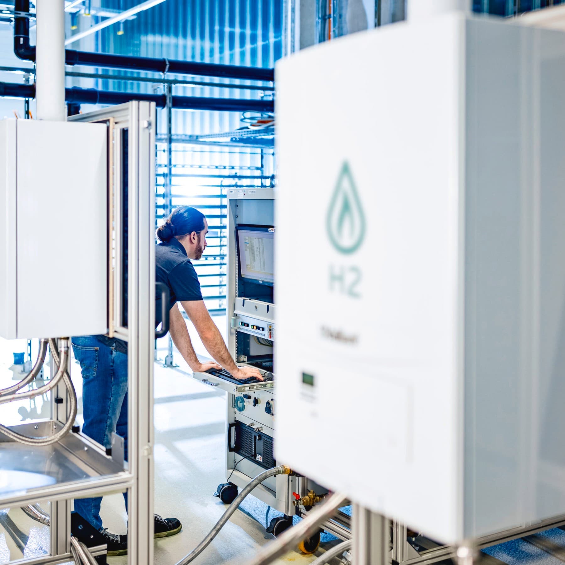 Installateur sur un banc d'essai vérifiant les données d'un essai avec de l'hydrogène | Vaillant