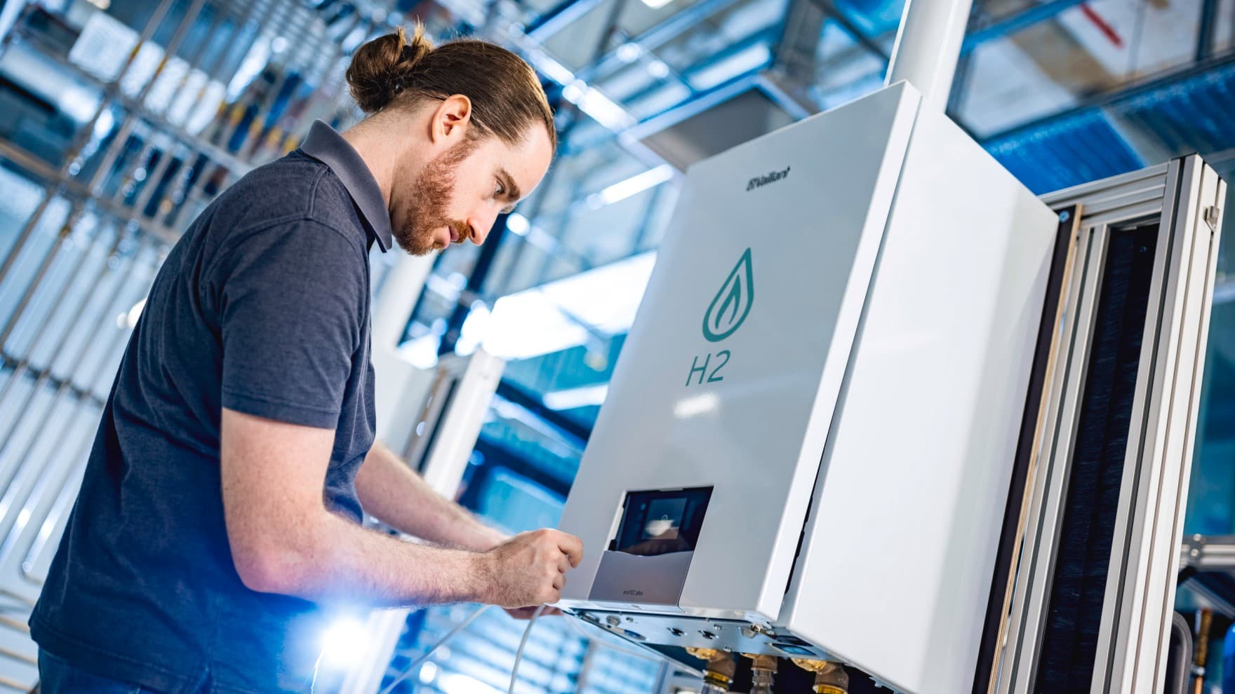 Installateur sur un banc d'essai vérifiant les données d'un essai avec de l'hydrogène | Vaillant