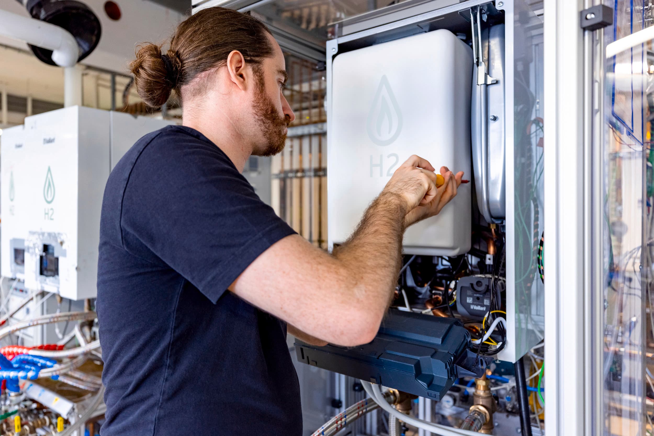 Technicien réglant une chaudière prête pour l'hydrogène | Vaillant