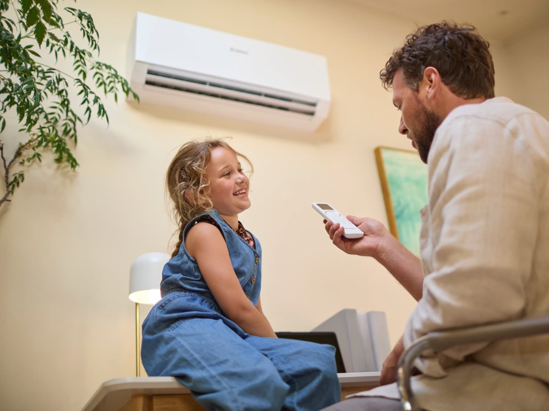 Un père et sa fille devant un climatiseur | Vaillant