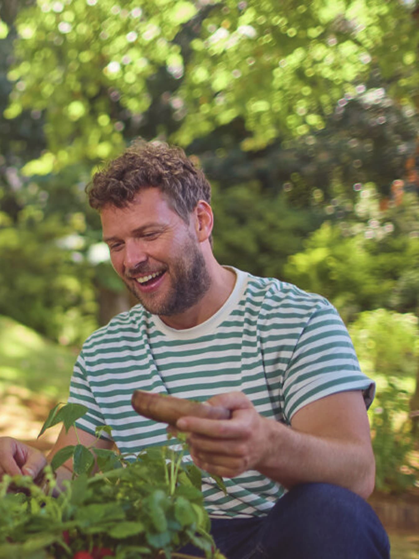 Un père et son fils jardinant avec un macaron d'aides financières | Vaillant