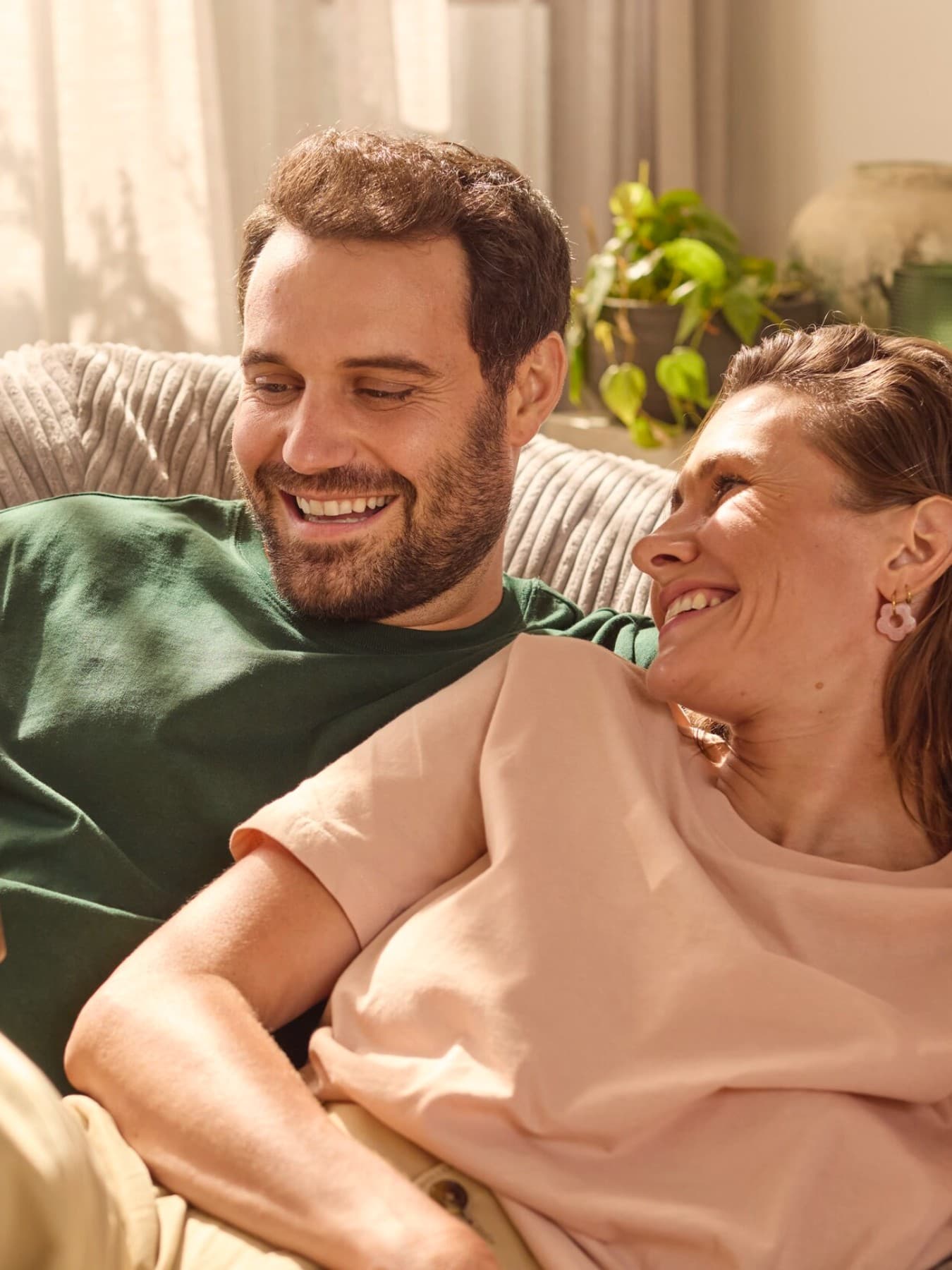 Couple assis sur un canapé regardant un téléphone | Vaillant