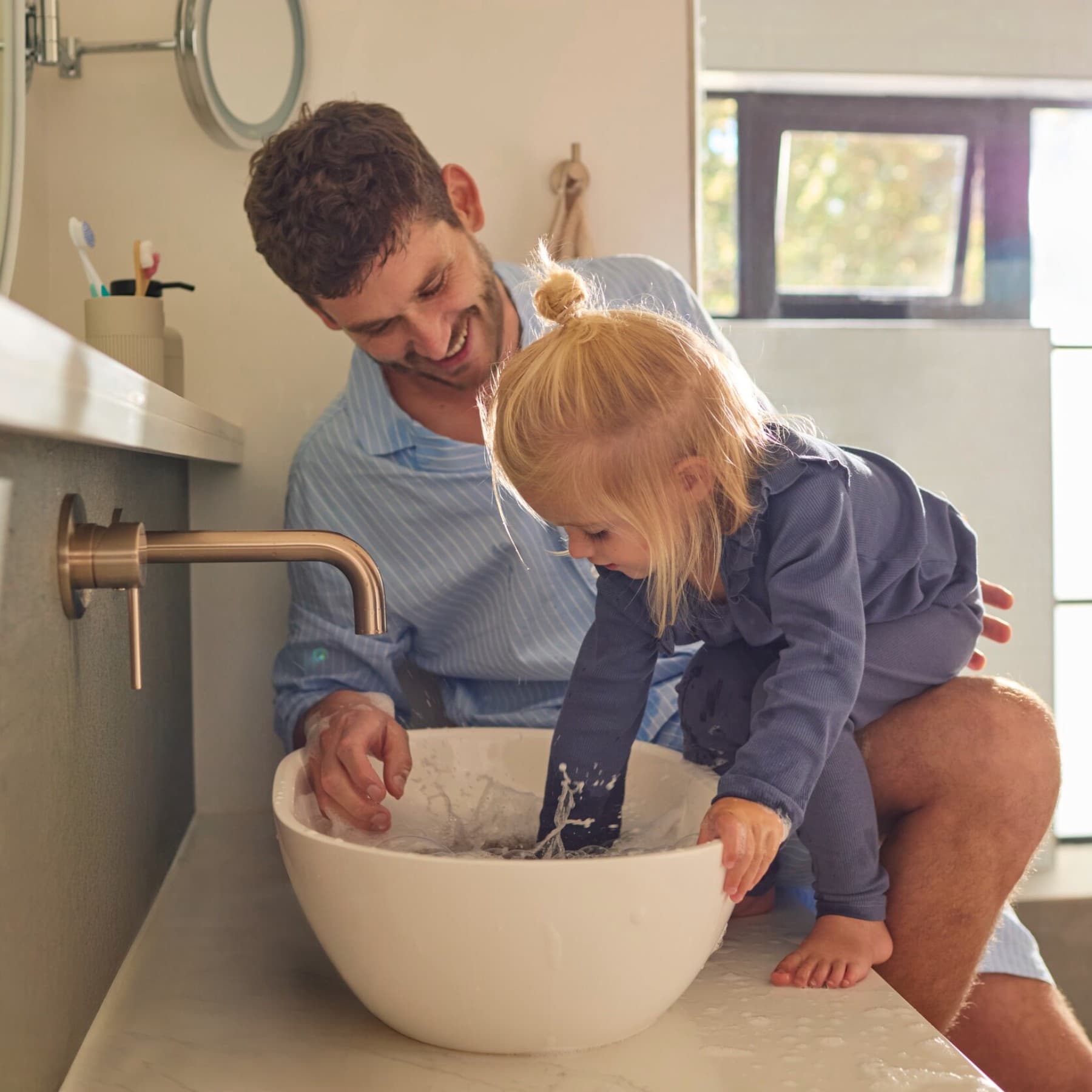 Enfant jouant avec de l'eau dans un bassin | Vaillant