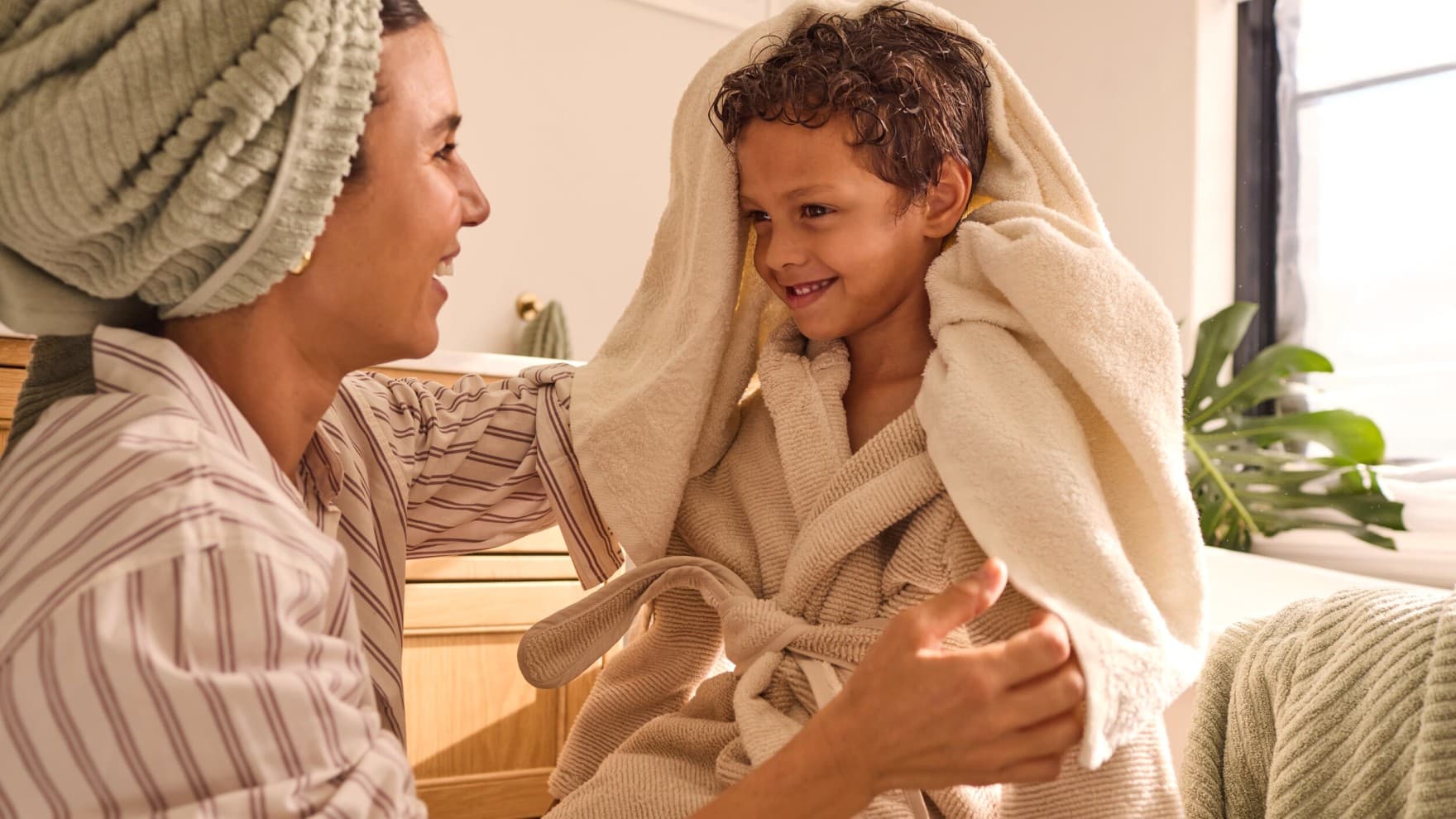 Une mère essuie son fils après la douche