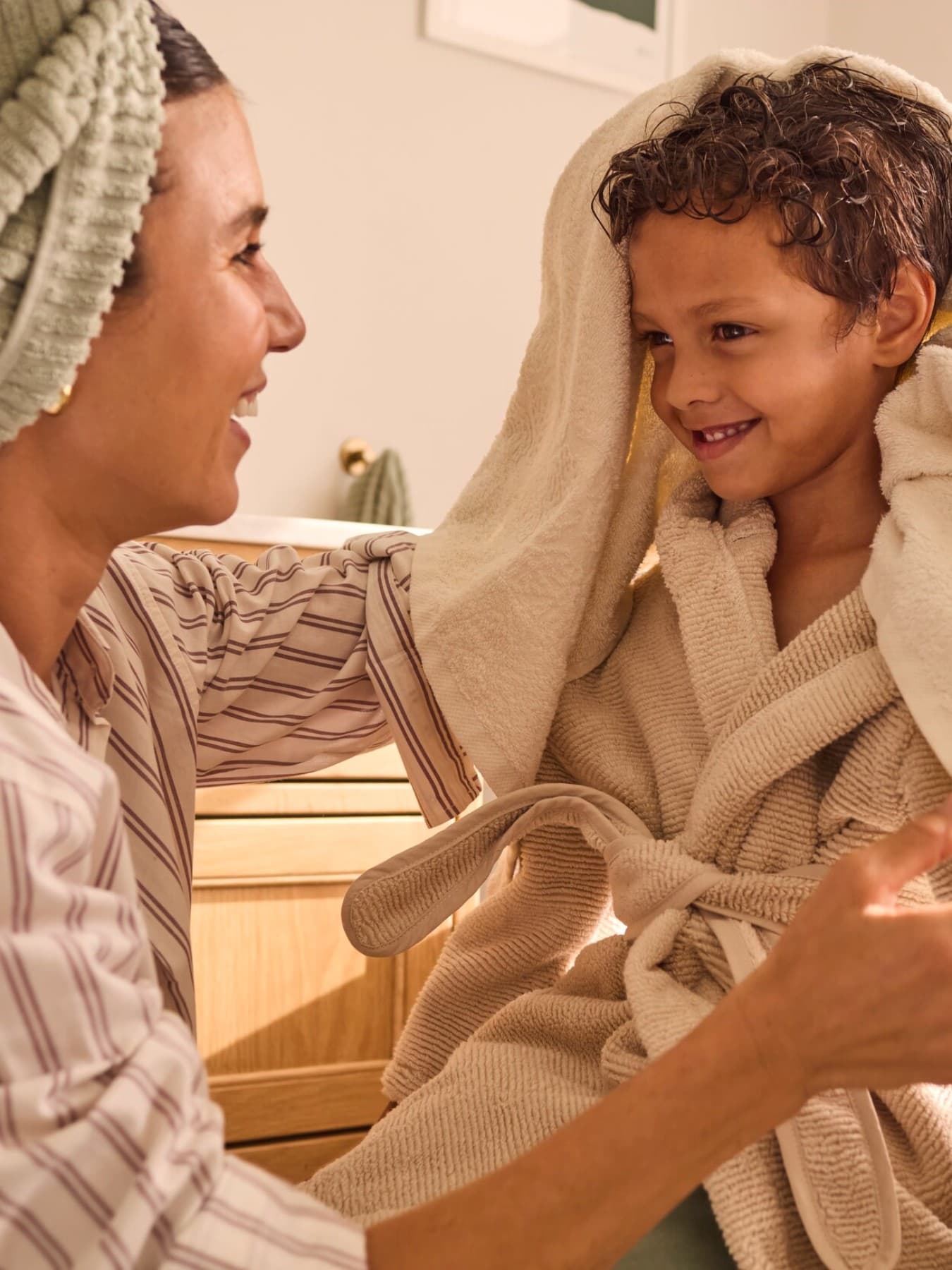 Une mère essuie son fils après la douche