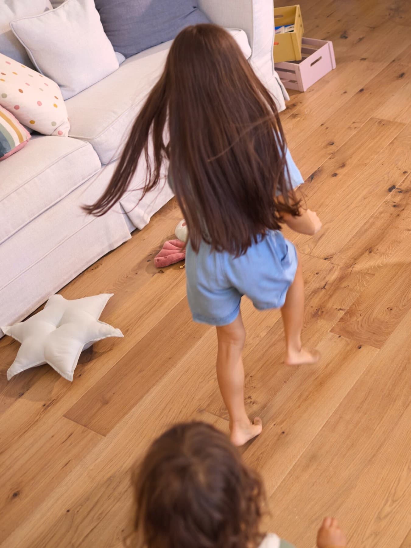 Deux enfants courant pieds nus sur le parquet de la maison | Vaillant
