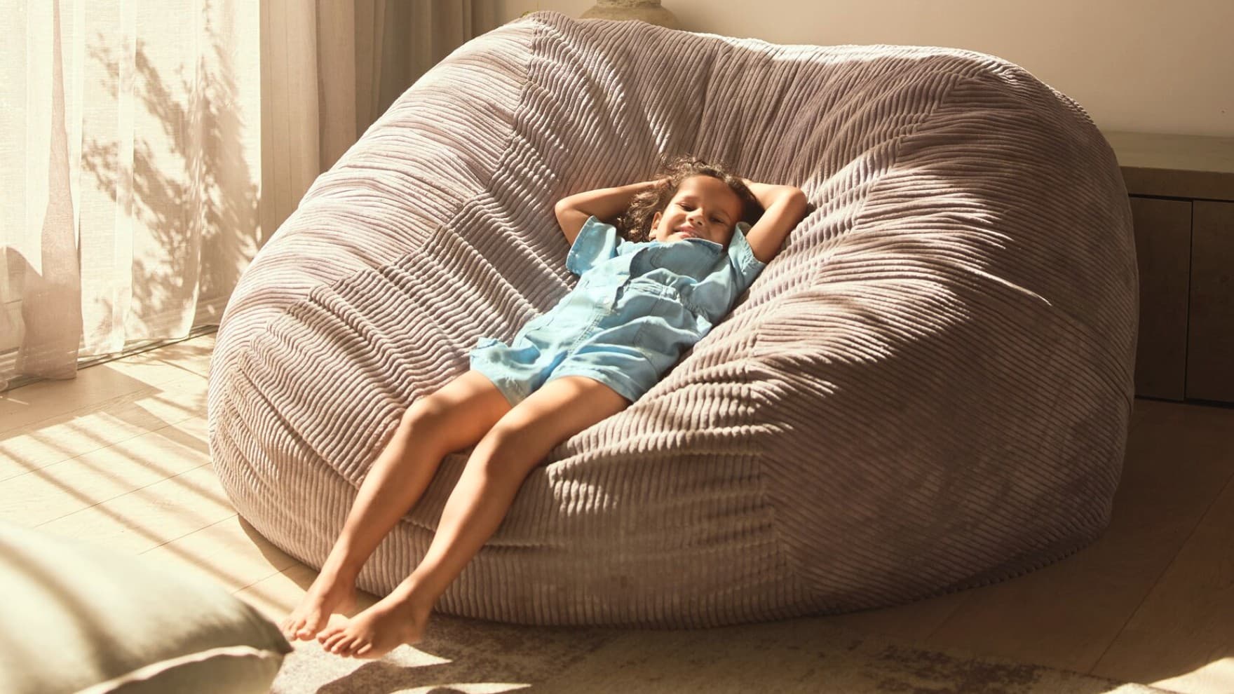 Une enfant se détend dans un pouf | Vaillant