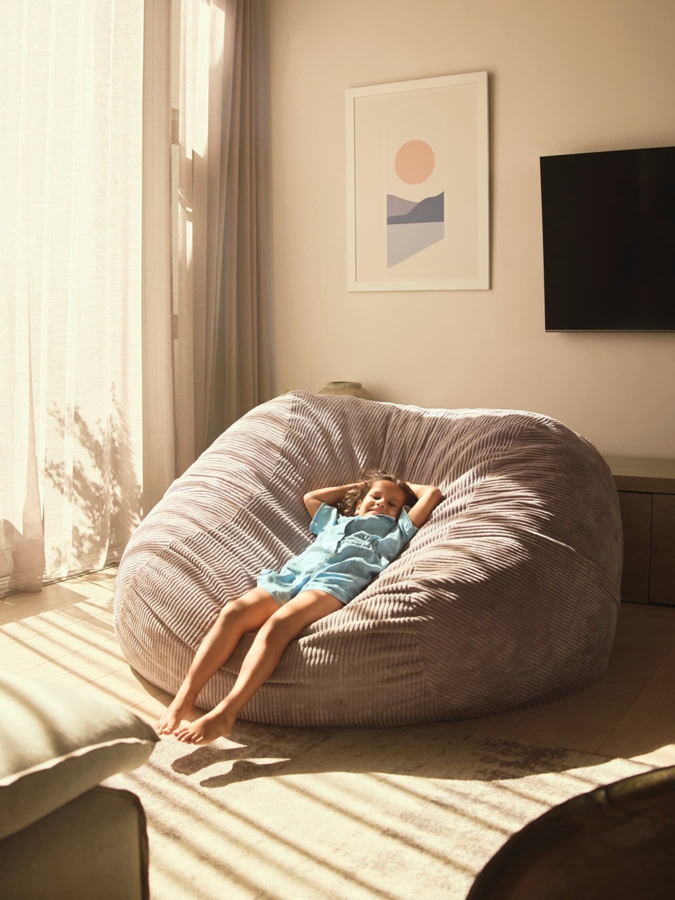 Une enfant se détend dans un pouf | Vaillant