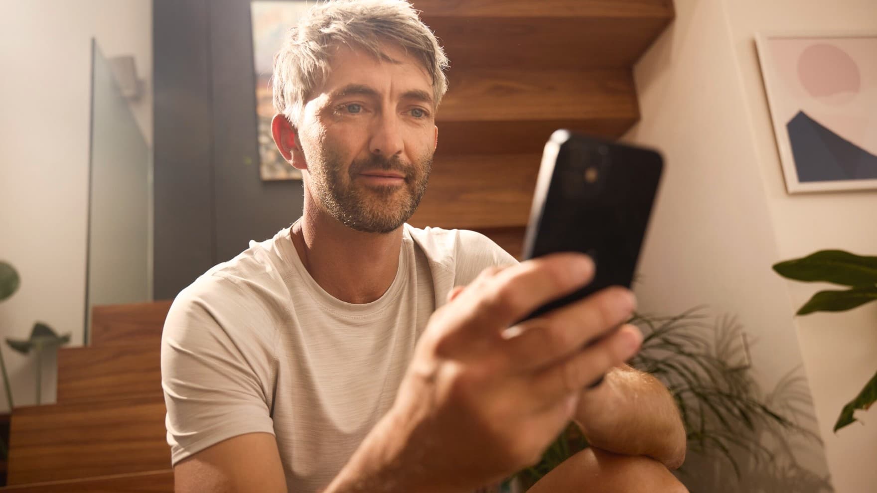 Un homme contrôle son système de chauffage via une application | Vaillant