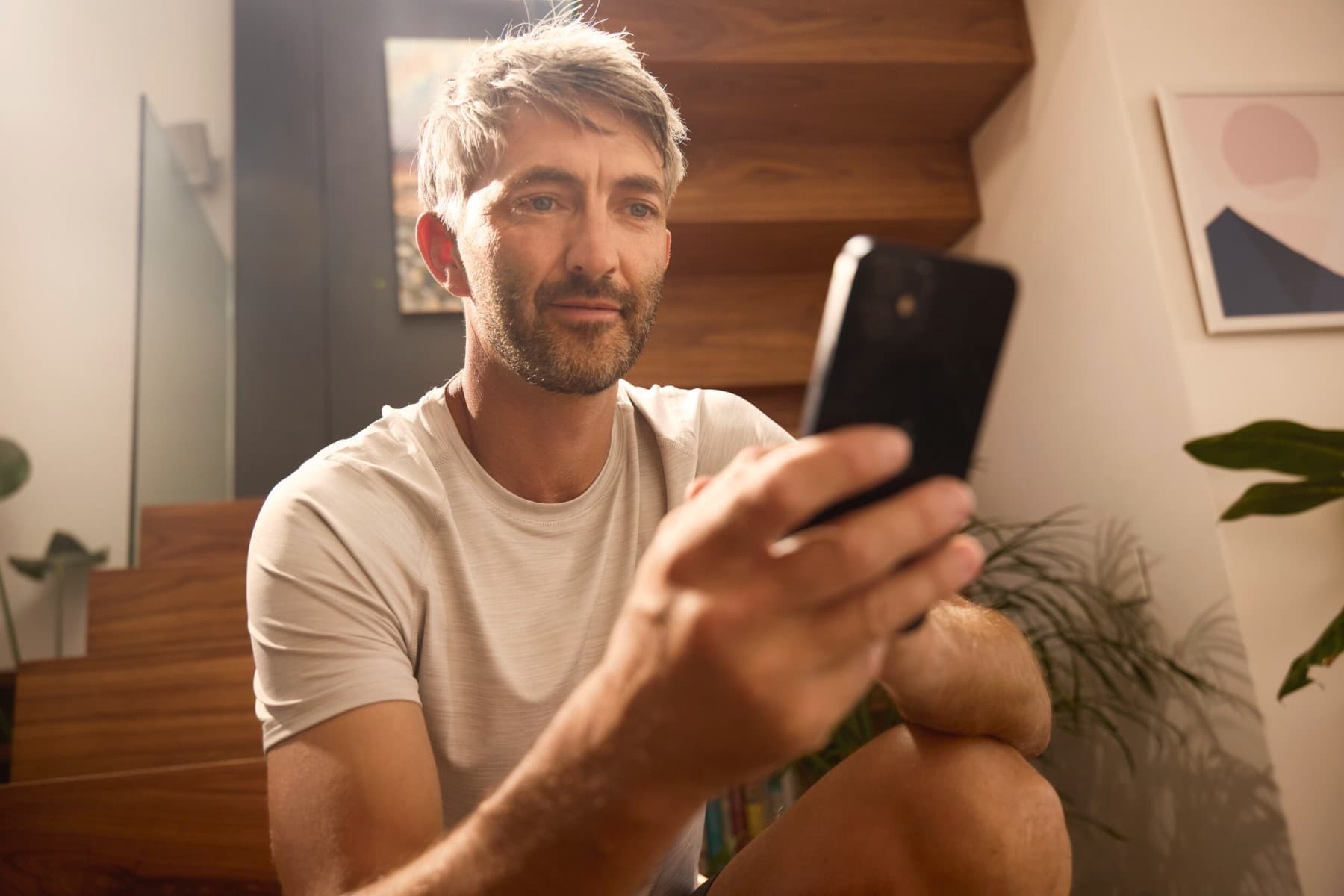 Un homme règle son chauffage sur son téléphone.
