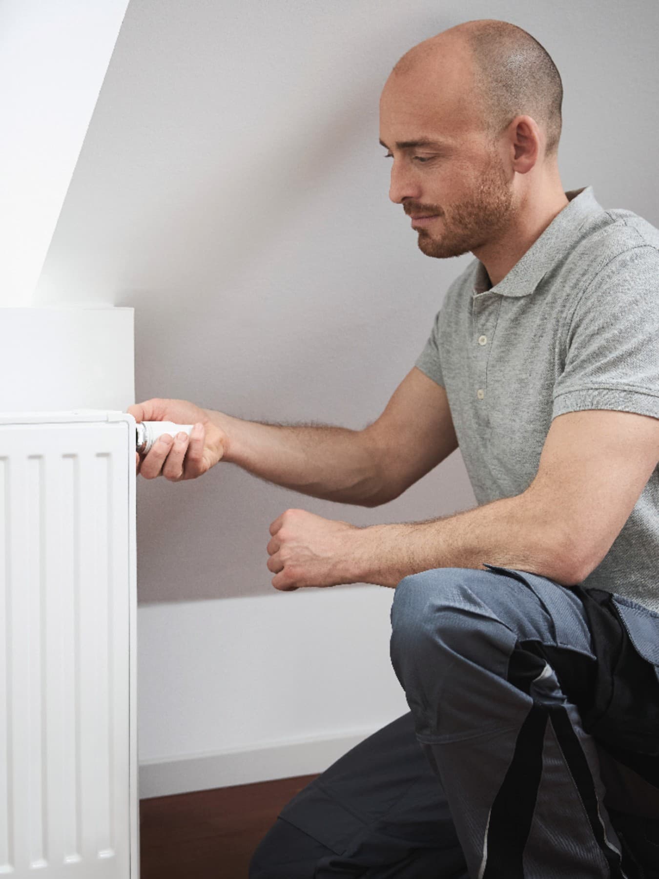 Installateur agenouillé sur le sol | Vaillant