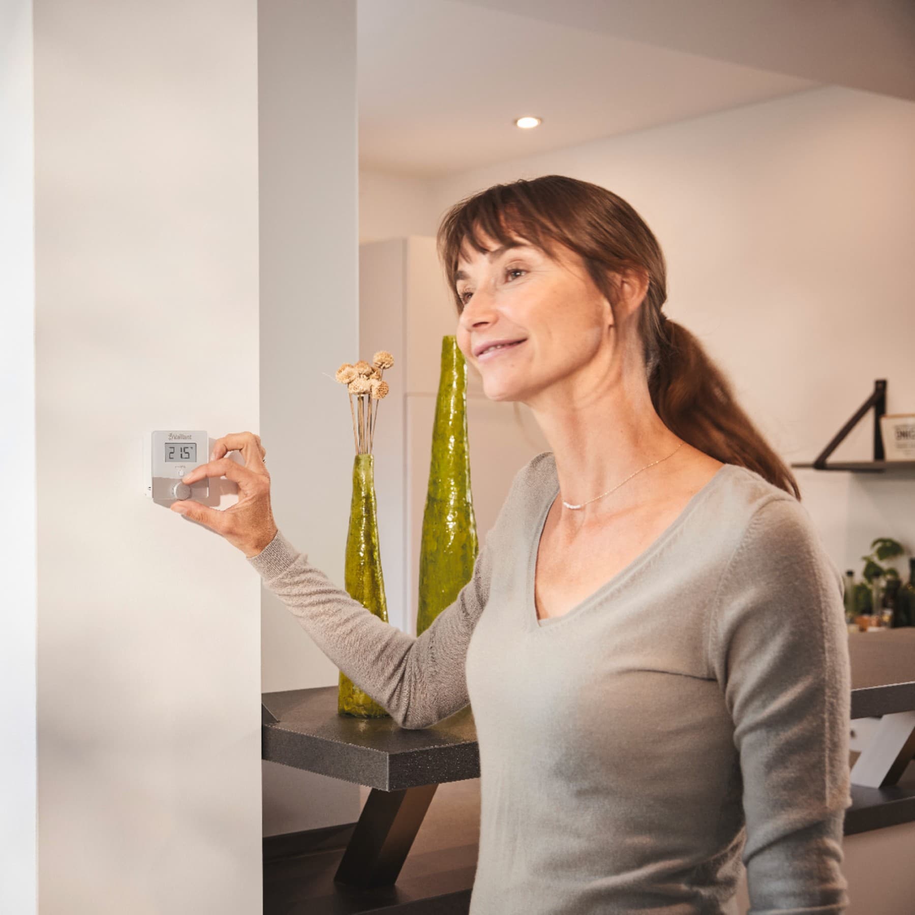 Femme réglant un thermostat mural
