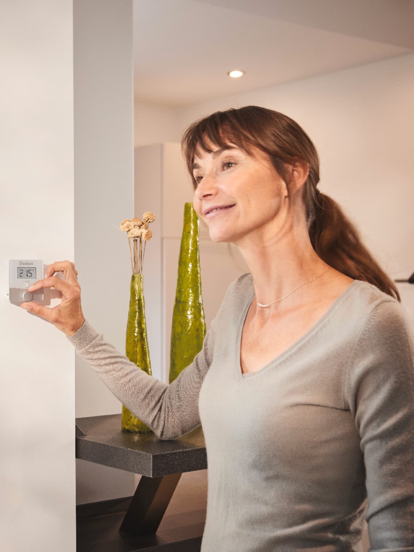 Femme réglant un thermostat mural