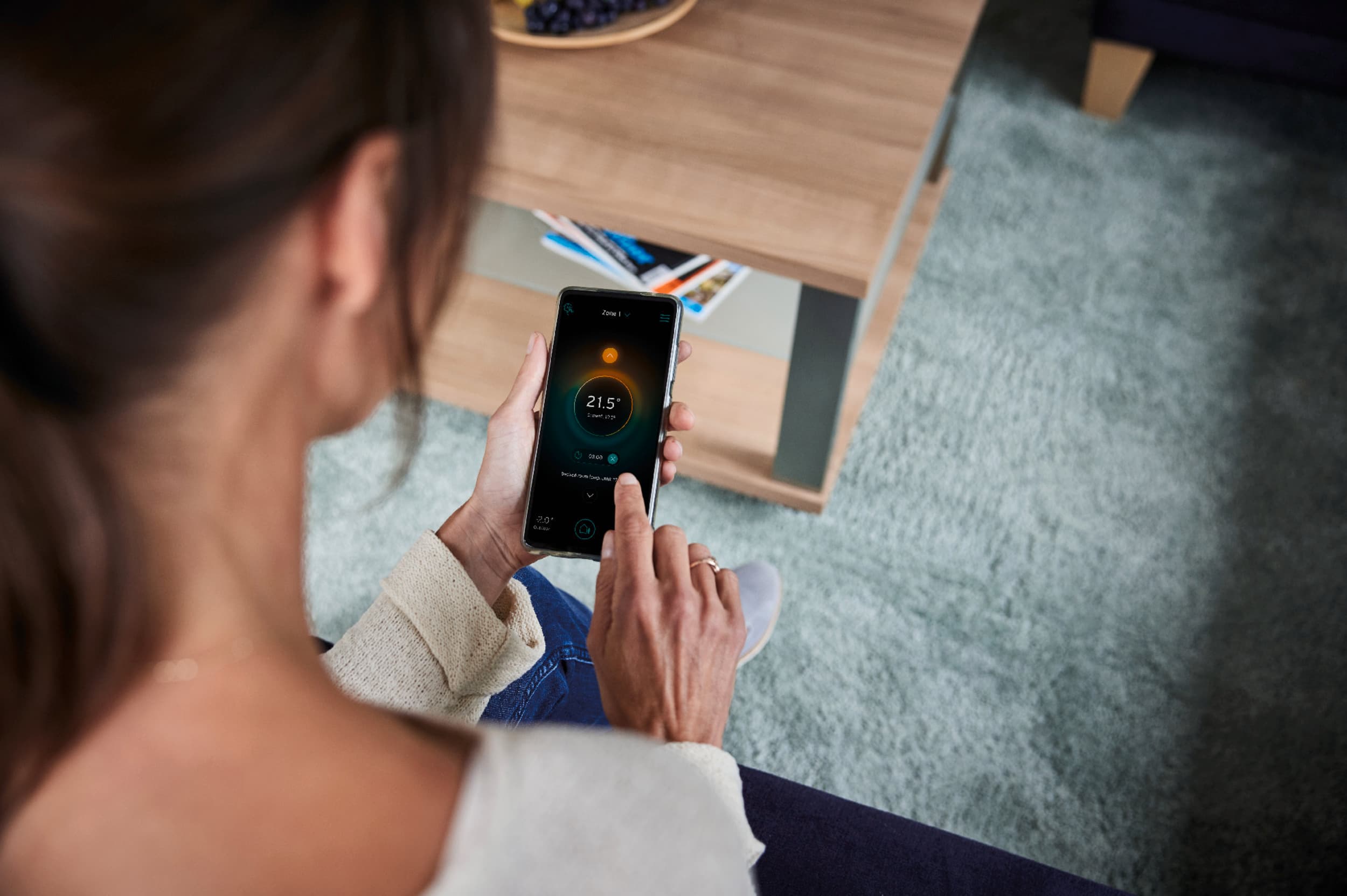 Une femme règle son chauffage via son smartphone