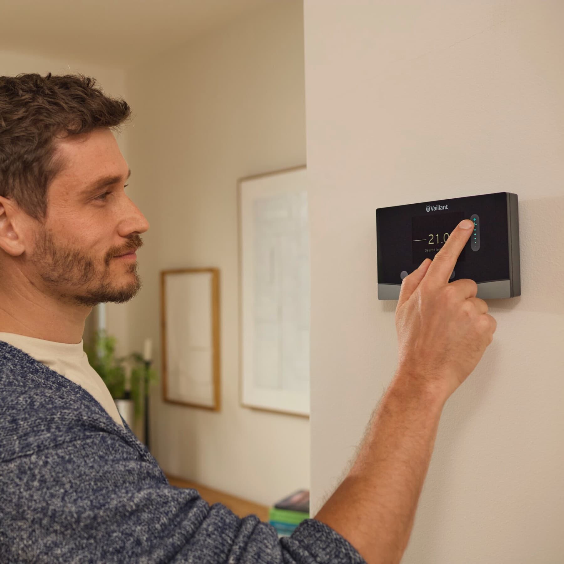 Homme réglant son chauffage avec son régulateur connecté