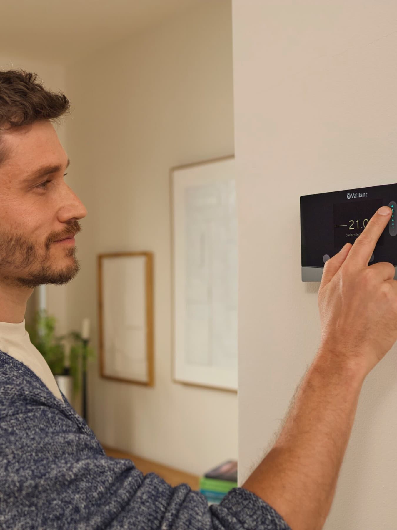 Homme réglant son chauffage avec son régulateur connecté