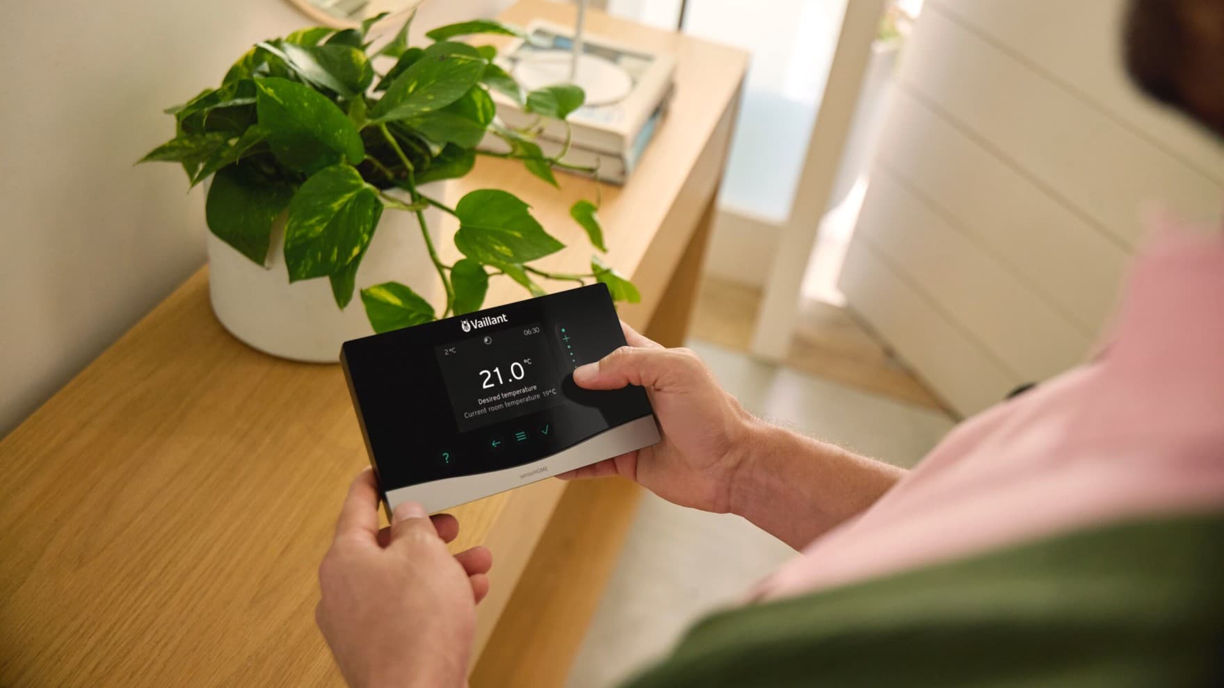 Homme tenant un régulateur connecté dans sa main | Vaillant