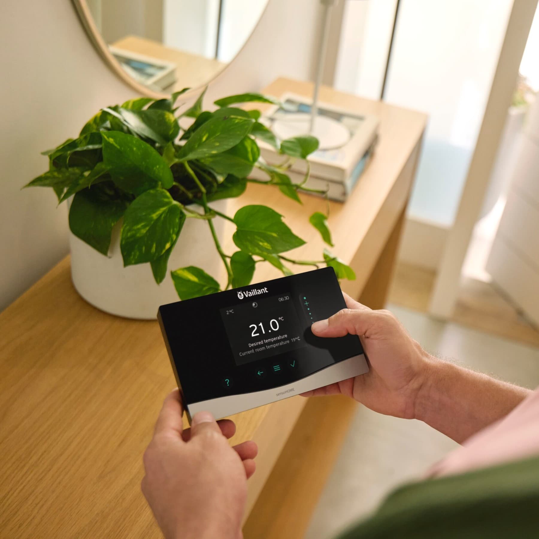 Une femme utilise un régulateur connecté | Vaillant