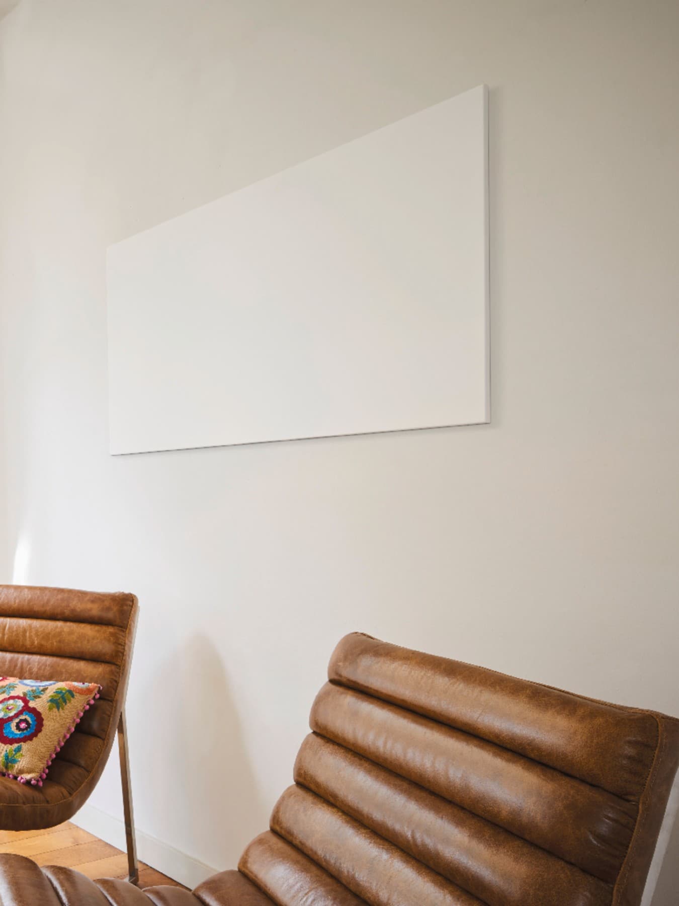 Un chauffage infrarouge au mur d'un salon | Vaillant