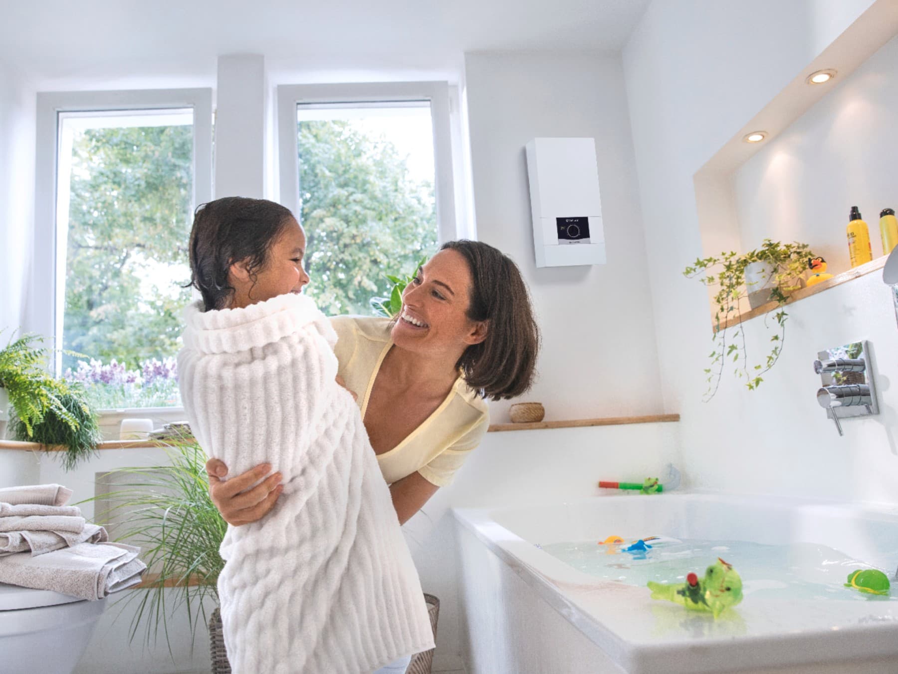 Une mère et sa fille profitent d'une eau toujours chaude dans la salle de bain | Vaillant