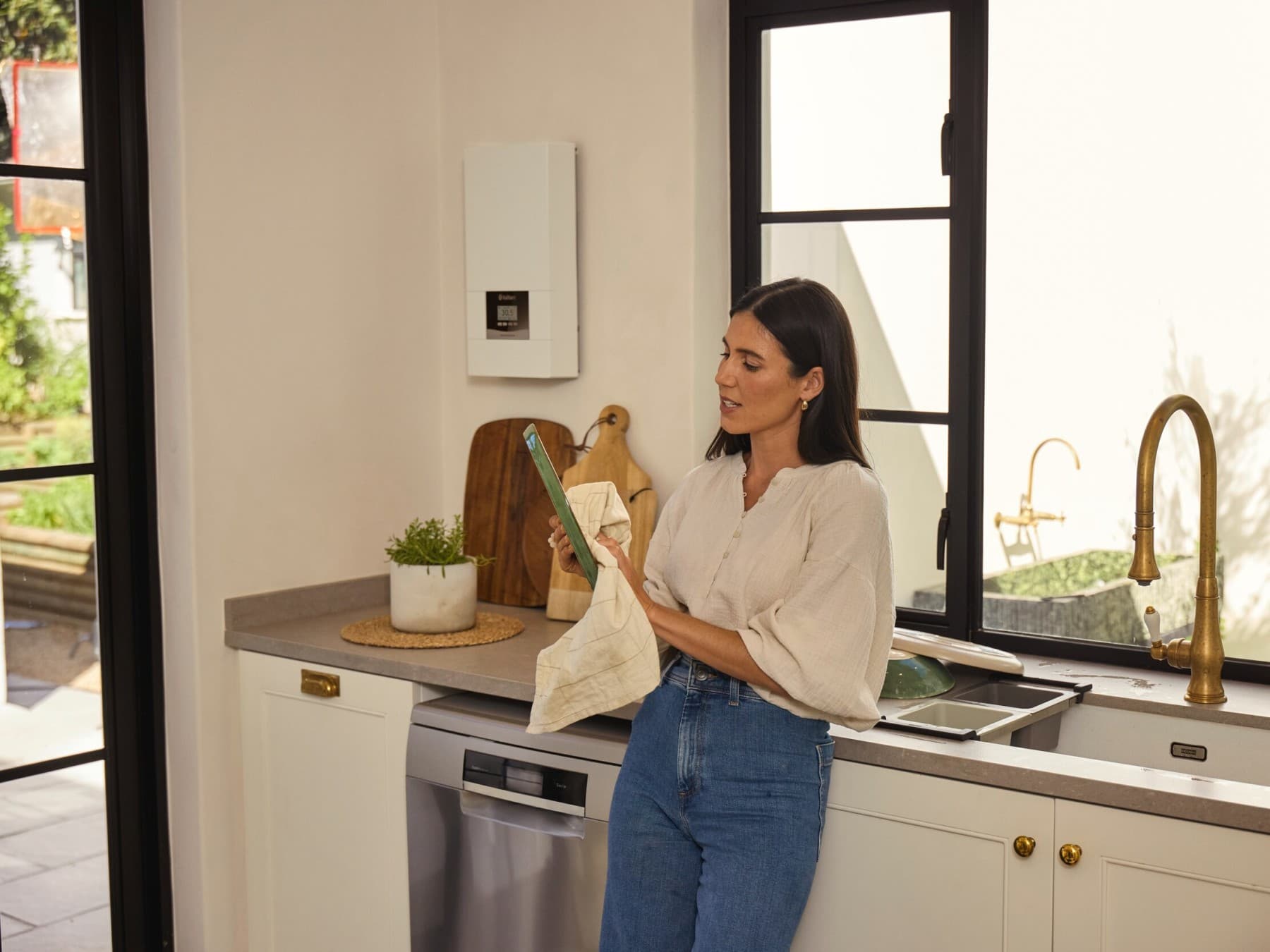 Femme faisant la vaisselle dans la cuisine | Vaillant