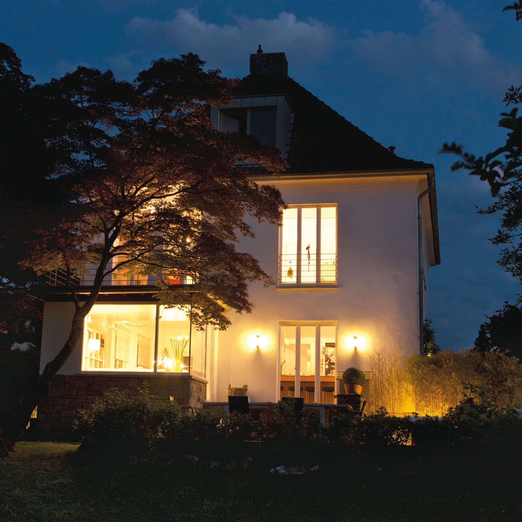 Vue d'une maison résidentielle avec une terrasse éclairé dans l'obscurité | Vaillant