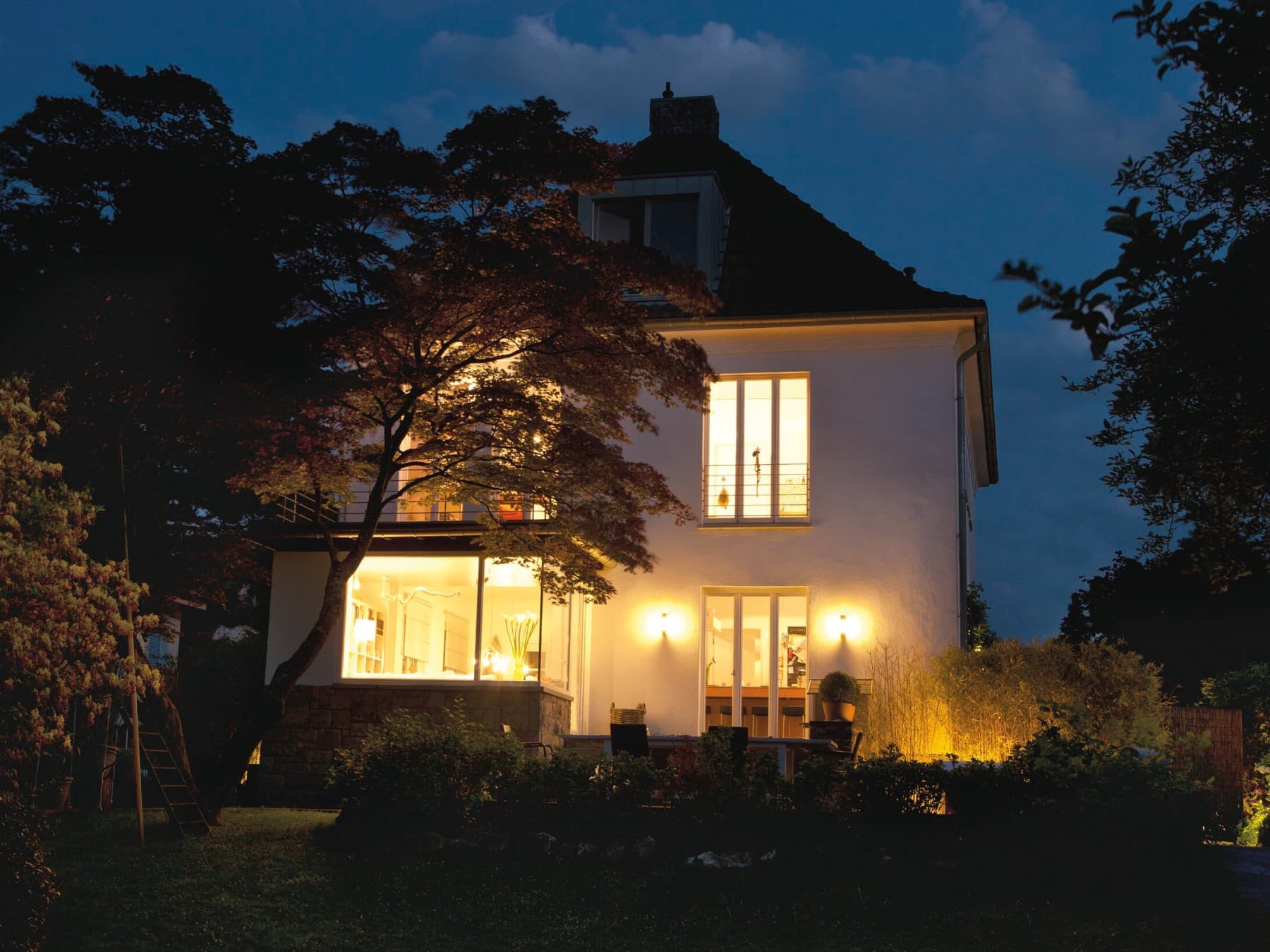 Vue d'une maison résidentielle avec une terrasse éclairé dans l'obscurité | Vaillant