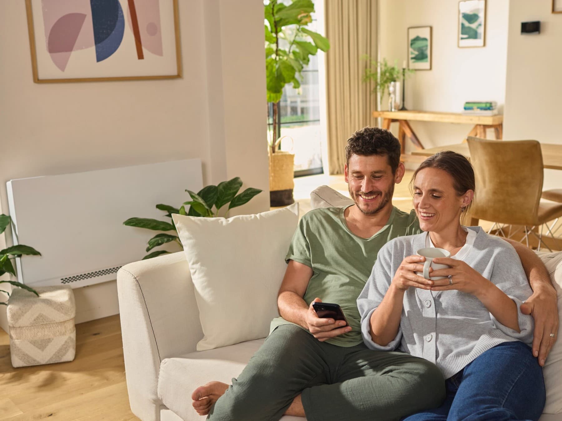 Un couple profitant de leur confort thermique avec un radiateur et une pompe à chaleur | Vaillant