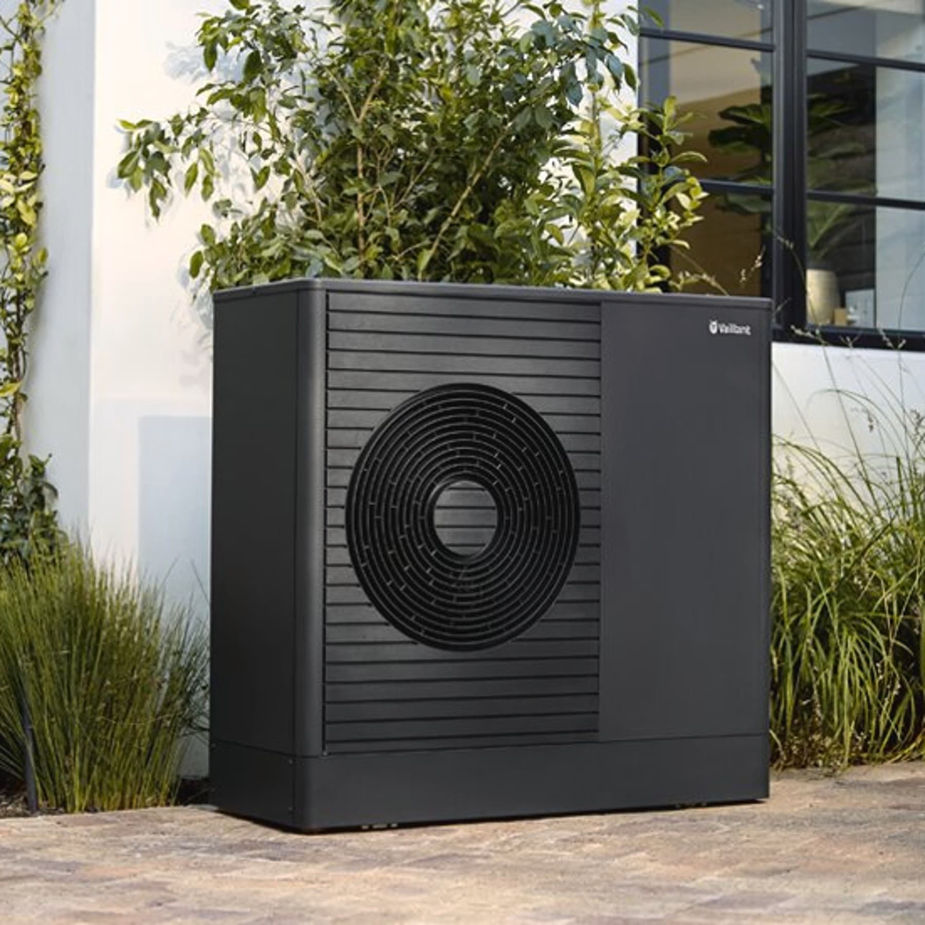 aroTHERM plus installée près des fenêtres d'une maison | Vaillant