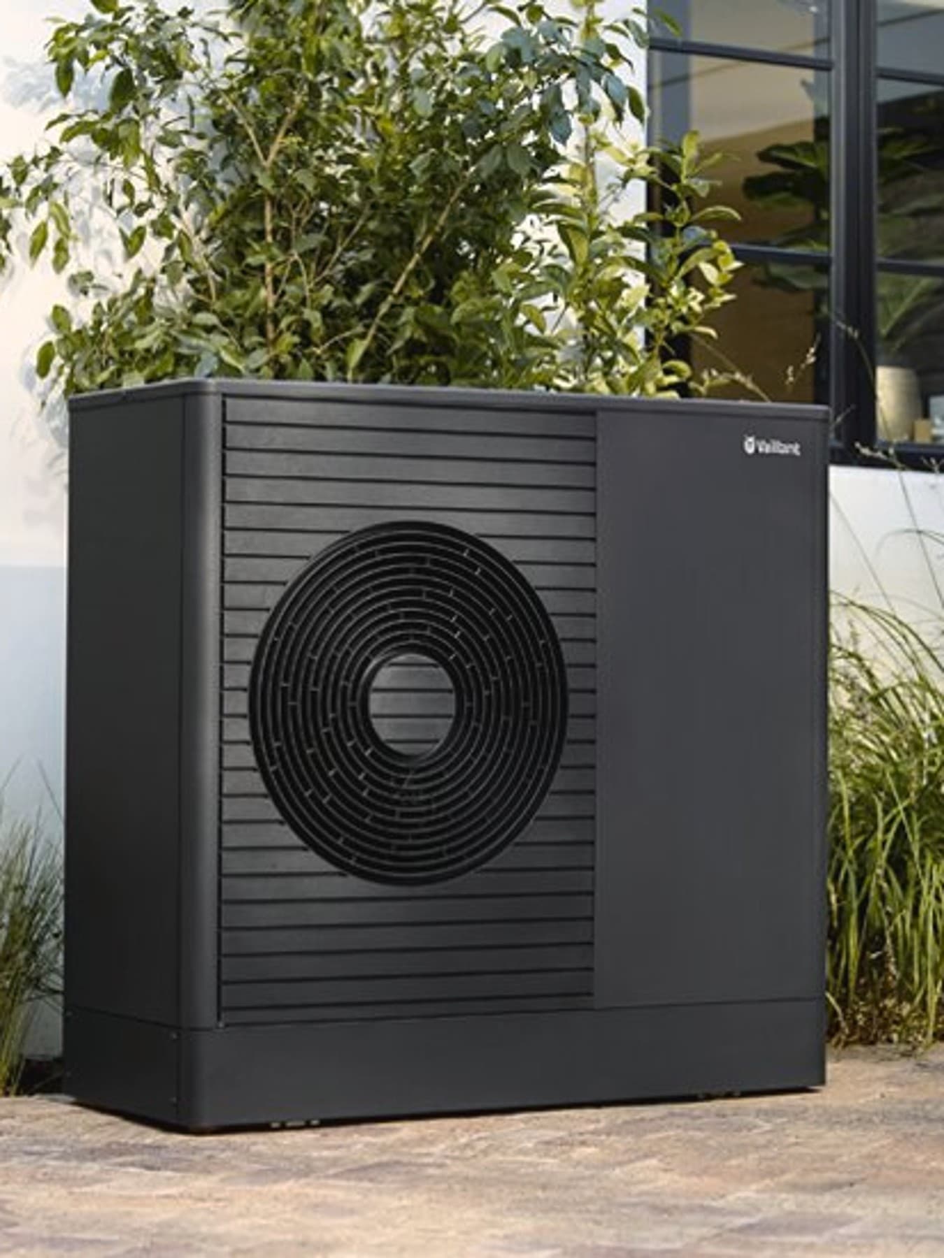 aroTHERM plus installée près des fenêtres d'une maison | Vaillant