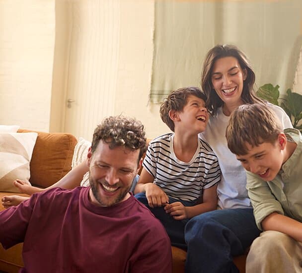 Une famille assise sur un canapé dans le salon | Vaillant