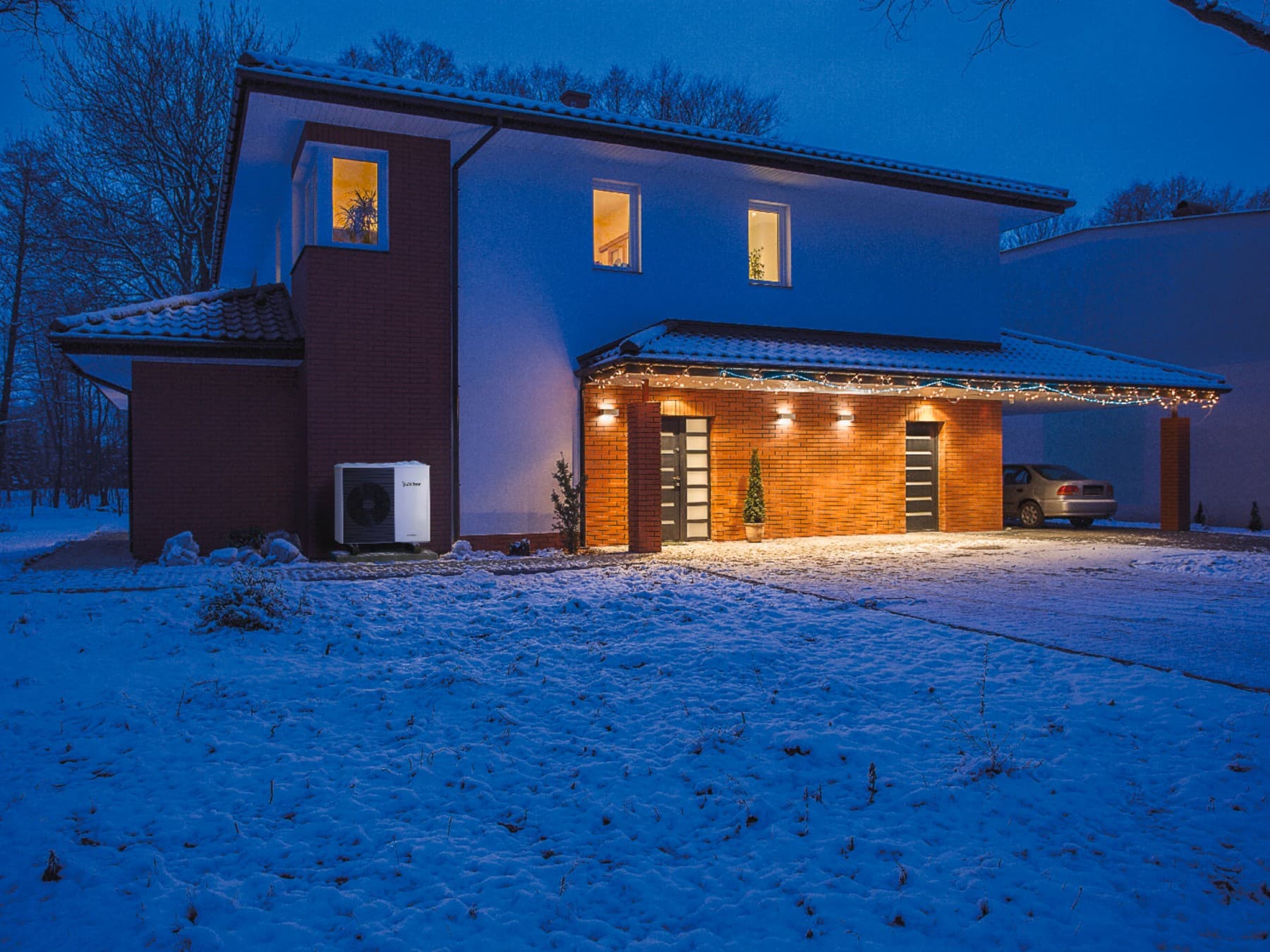 Une maison éclairée de nuit en plein hiver | Vaillant