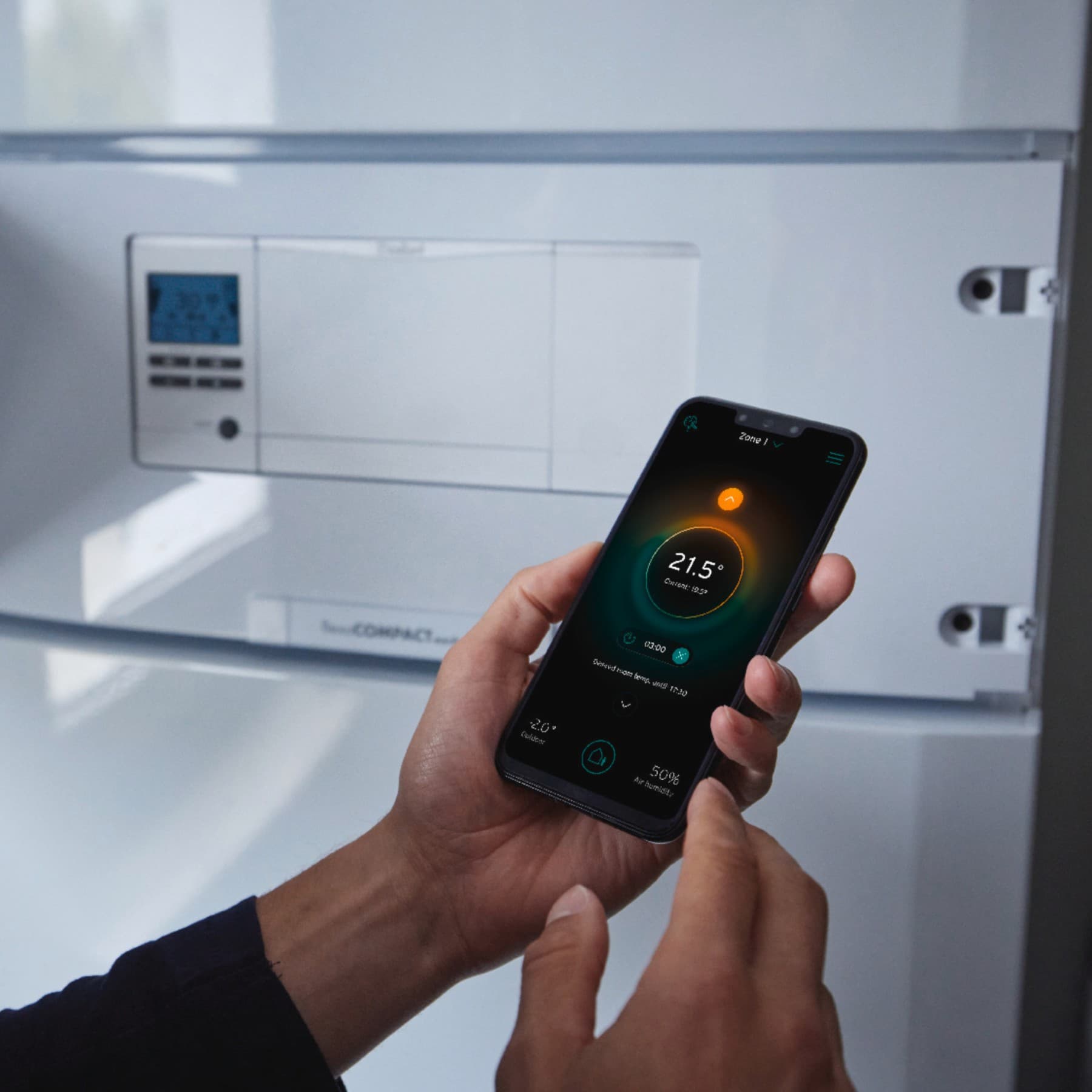 Un homme règle la température sur son téléphone | Vaillant