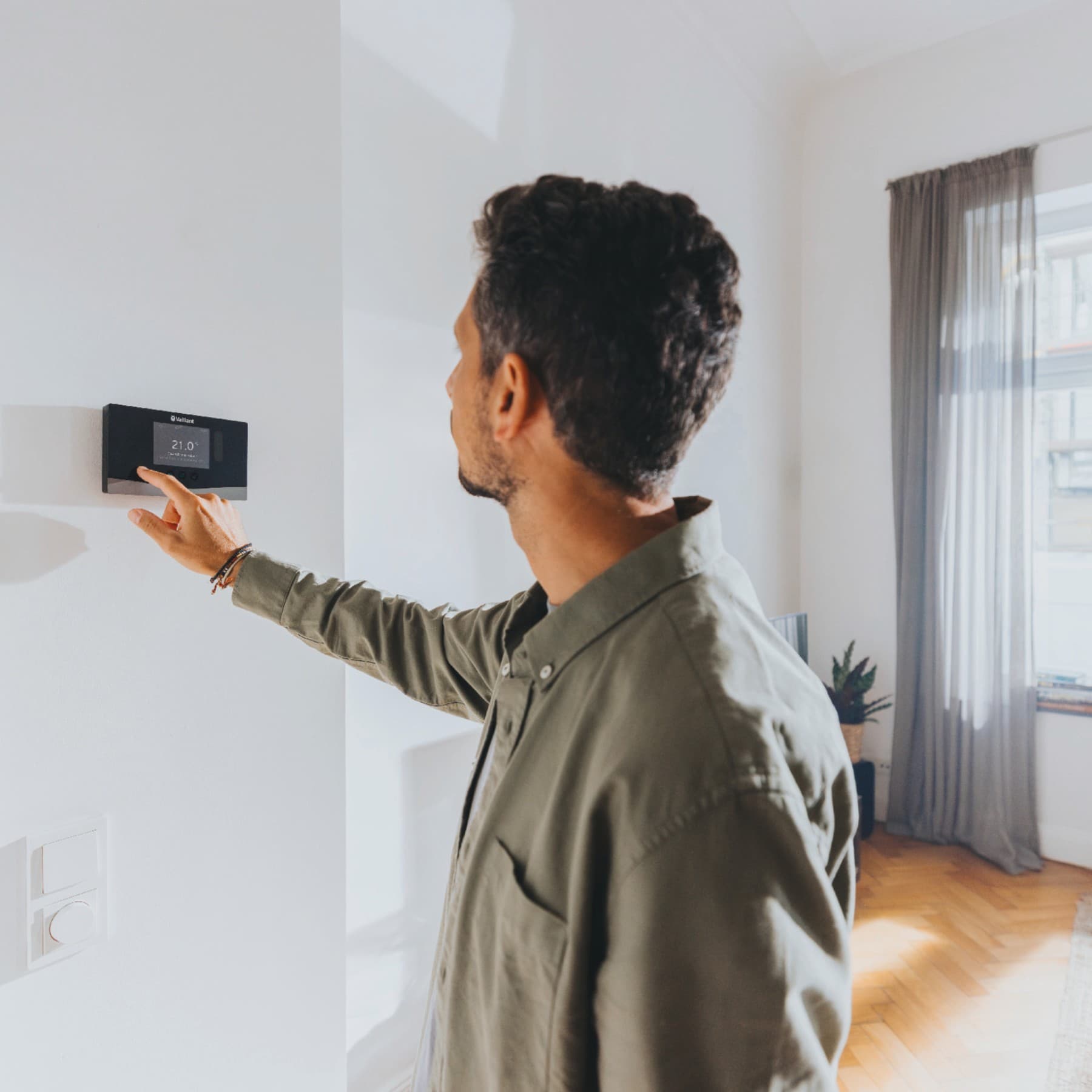 Homme installant un dispositif de mise en veille nocturne | Vaillant