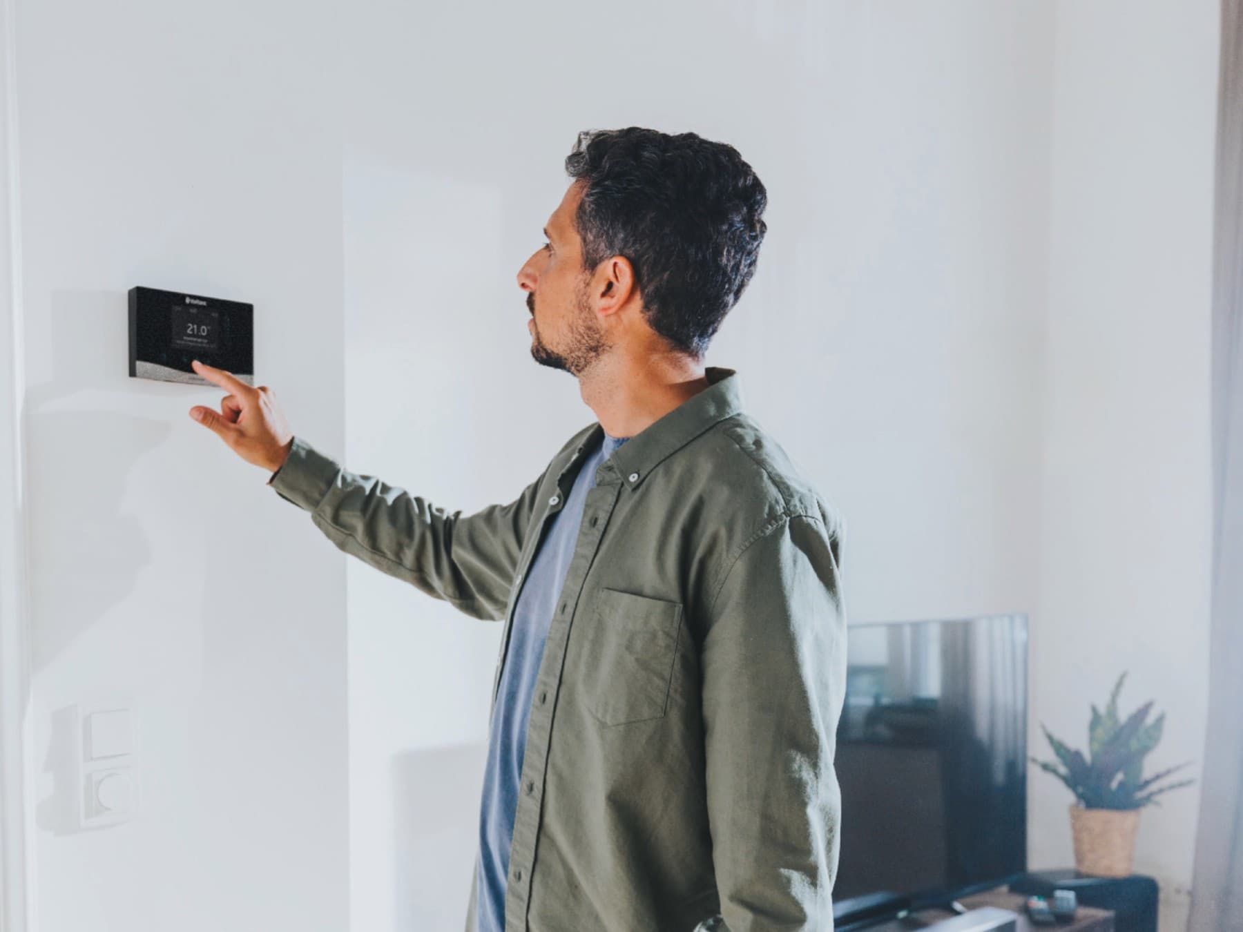L'homme effectue des réglages sur le régulateur | Vaillant
