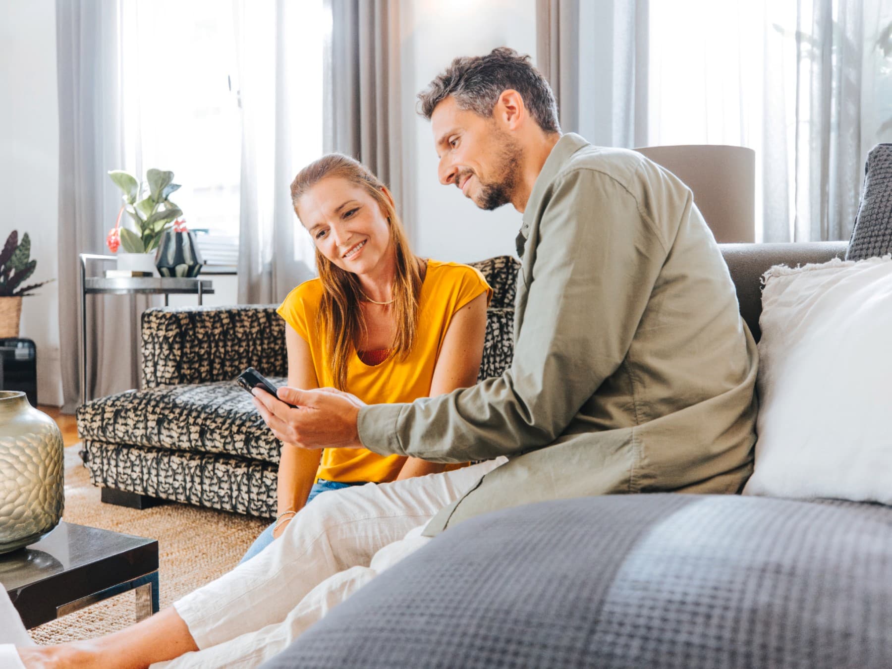 Couple contrôlant leur consommation d'énergie sur leur smartphone | Vaillant