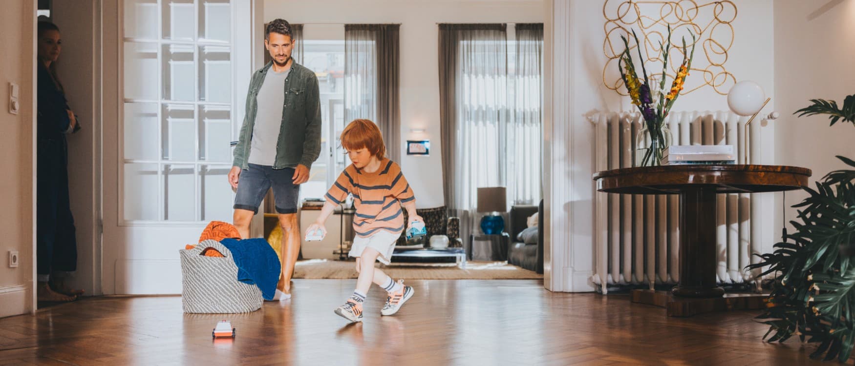 Le père regarde son fils jouer dans le salon | Vaillant