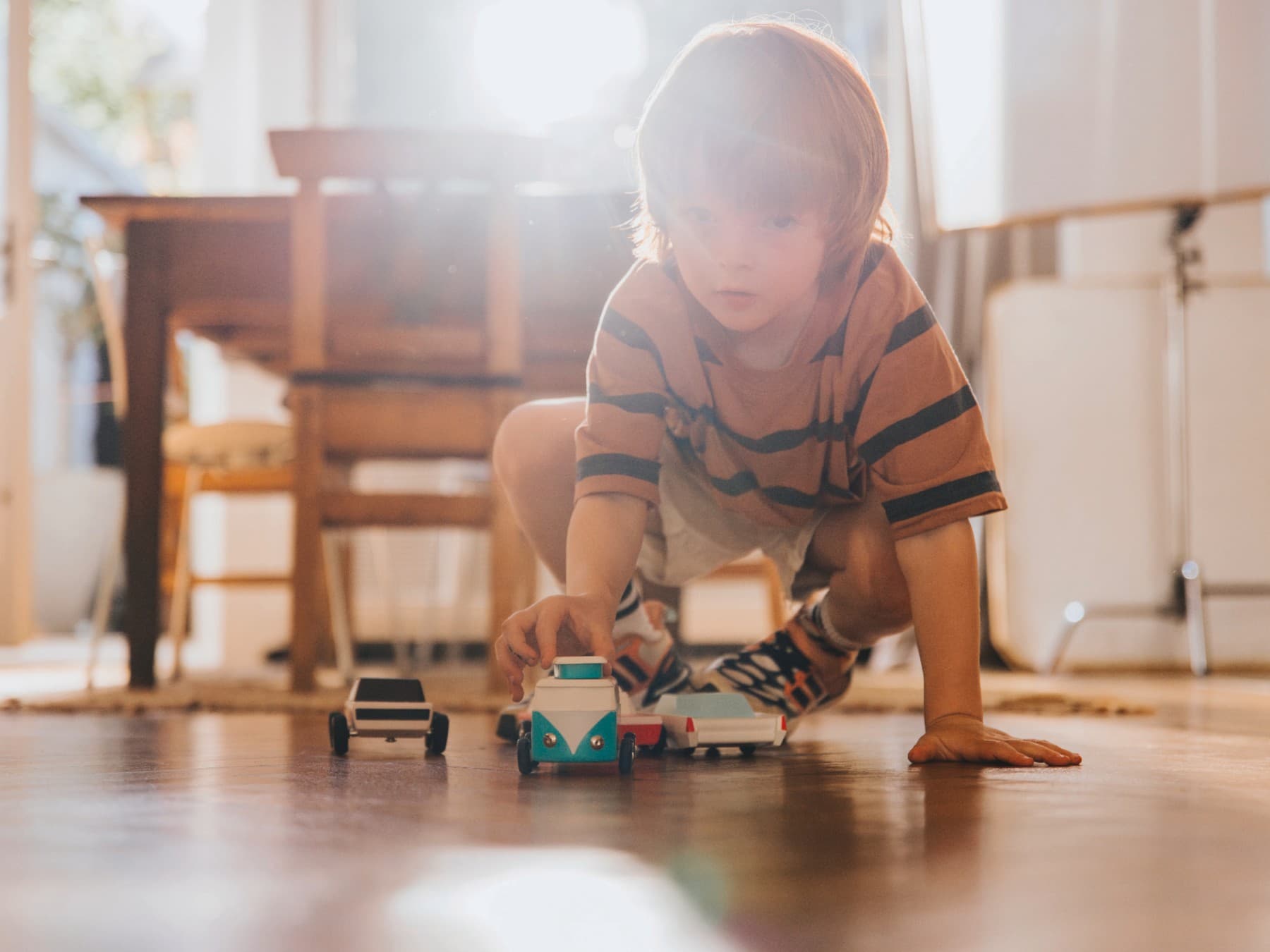 Enfant jouant par terre avec des voitures | Vaillant