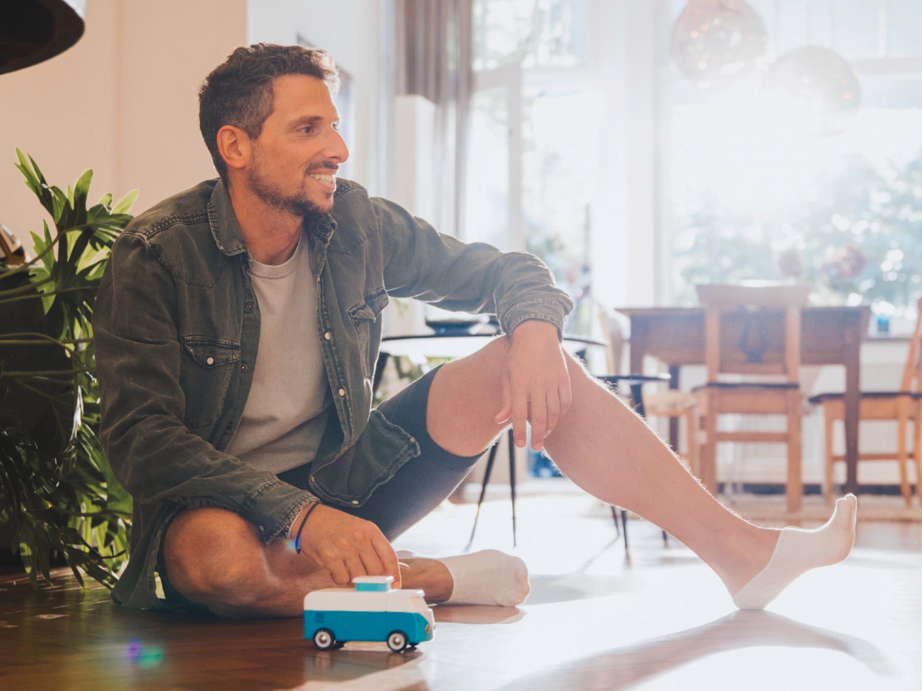 Homme assis par terre sur son plancher chauffant | Vaillant