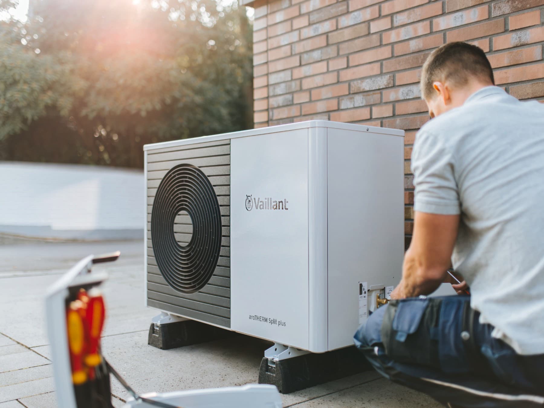 Un installateur met en place une unité extérieure de pompe à chaleur | Vaillant