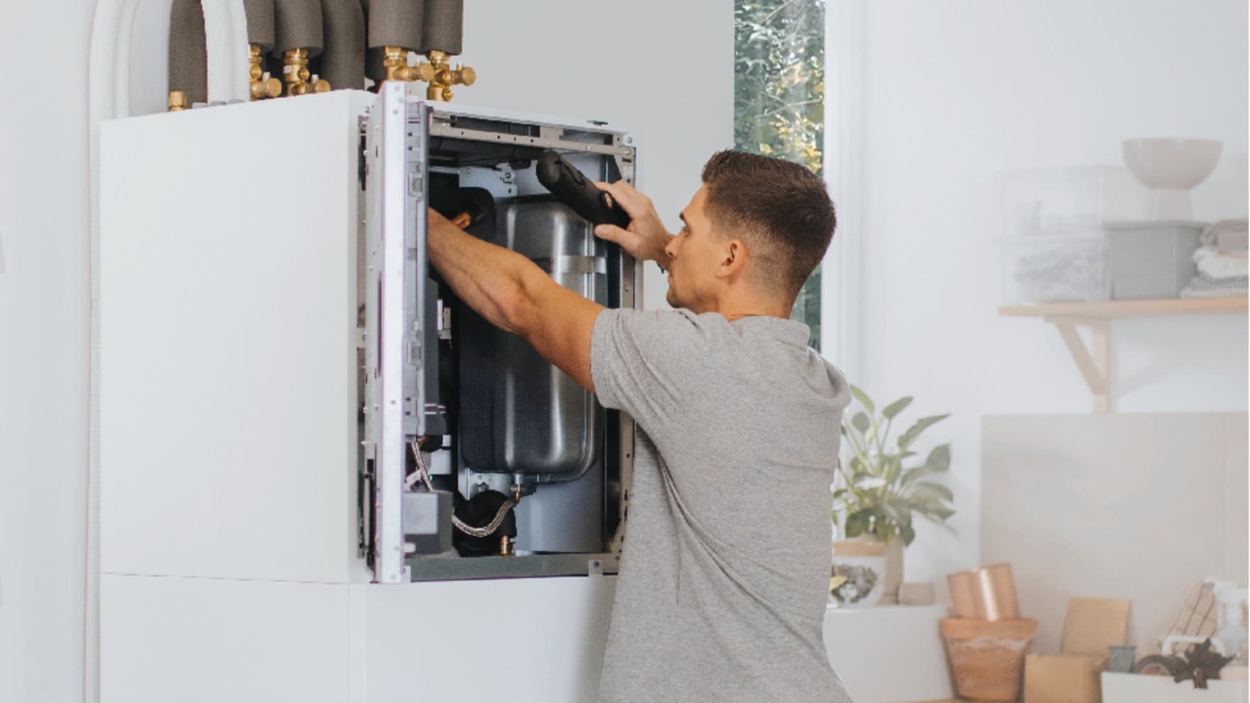 Installateur travaillant sur une unité intérieure d'une pompe à chaleur | Vaillant