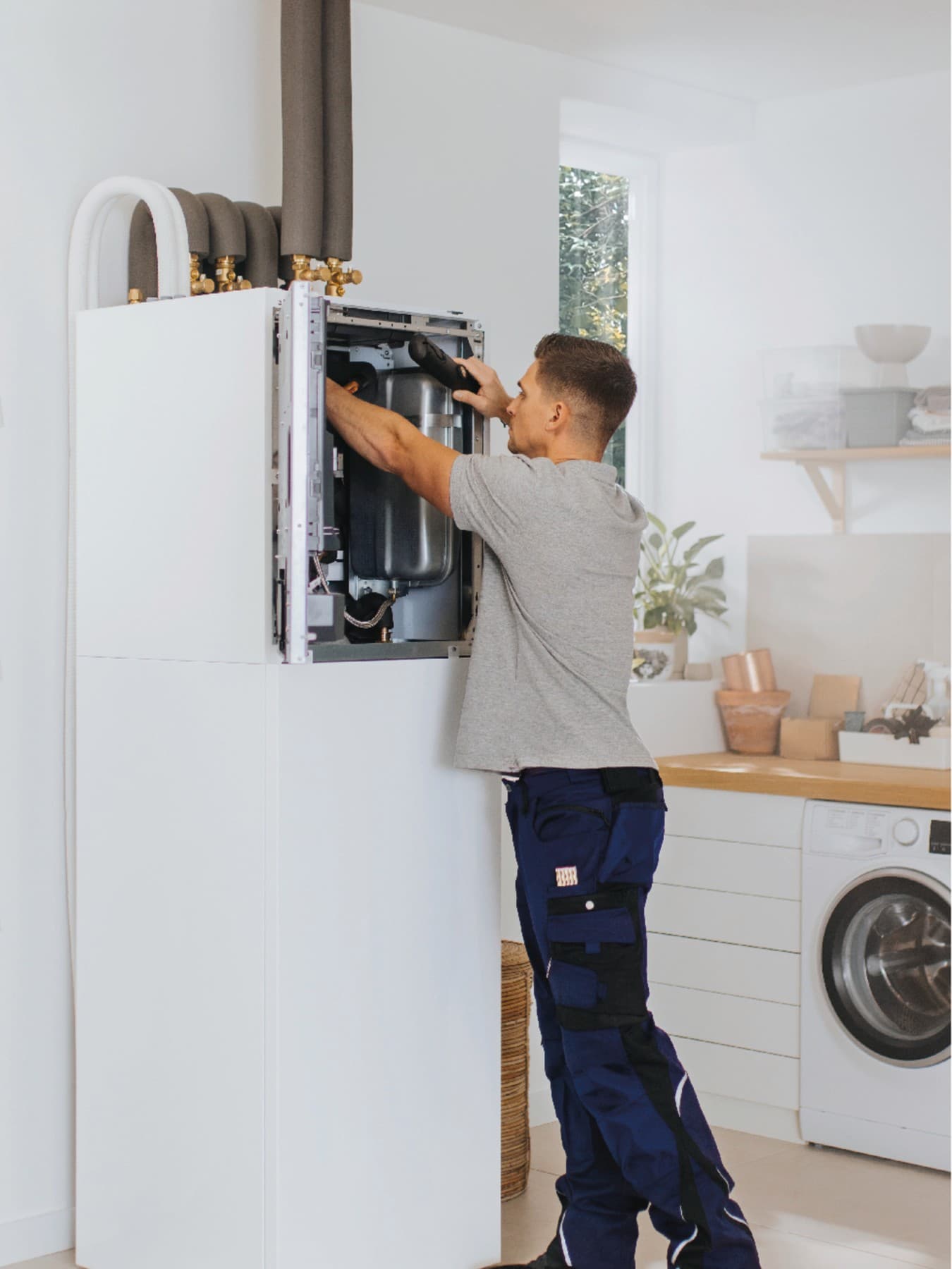 Installateur travaillant sur une unité intérieure d'une pompe à chaleur | Vaillant