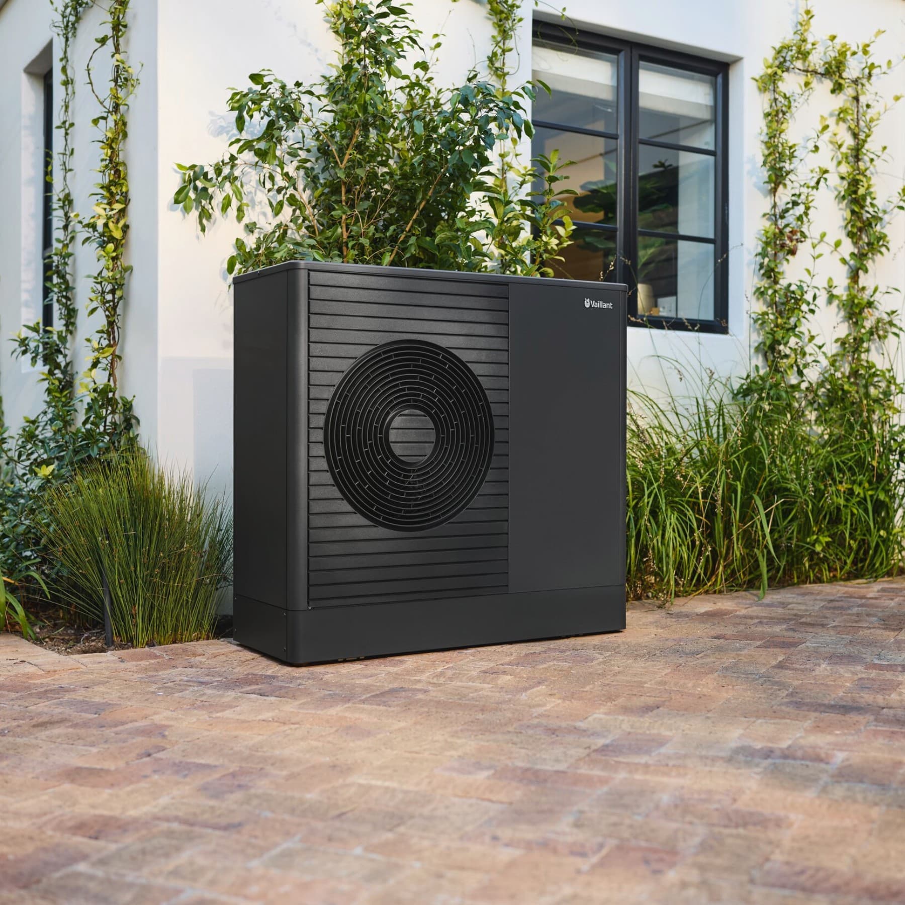 Pompe à chaleur dans le jardin devant la maison | Vaillant