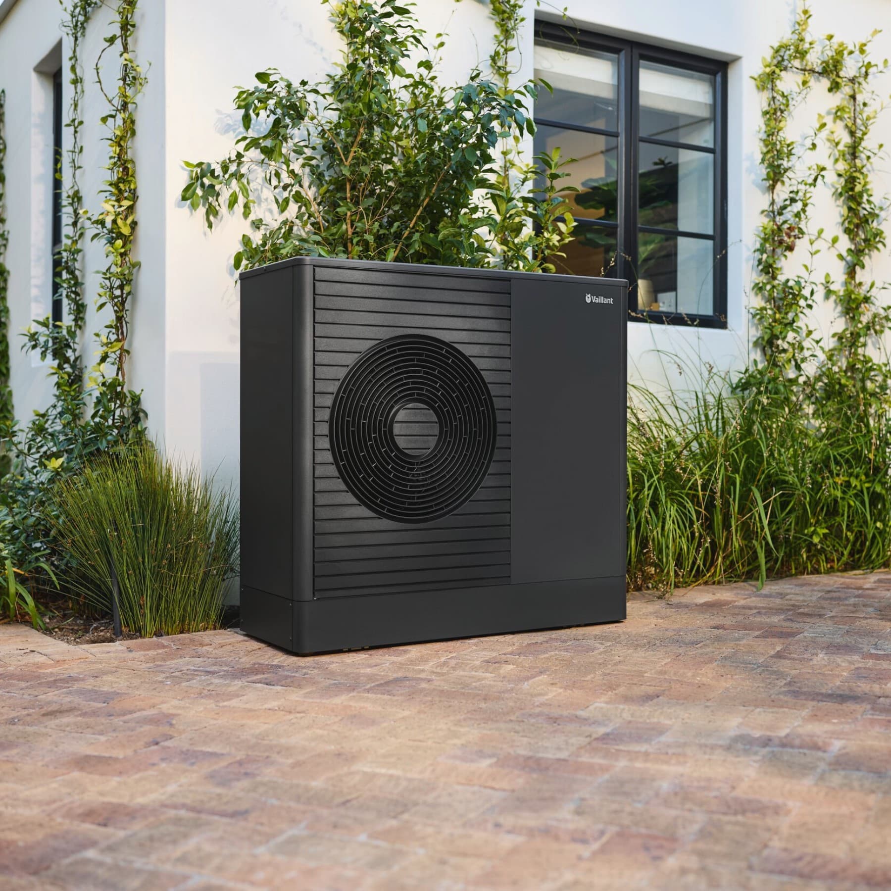 Une unité extérieure anthracite installée le long d'un mur | Vaillant