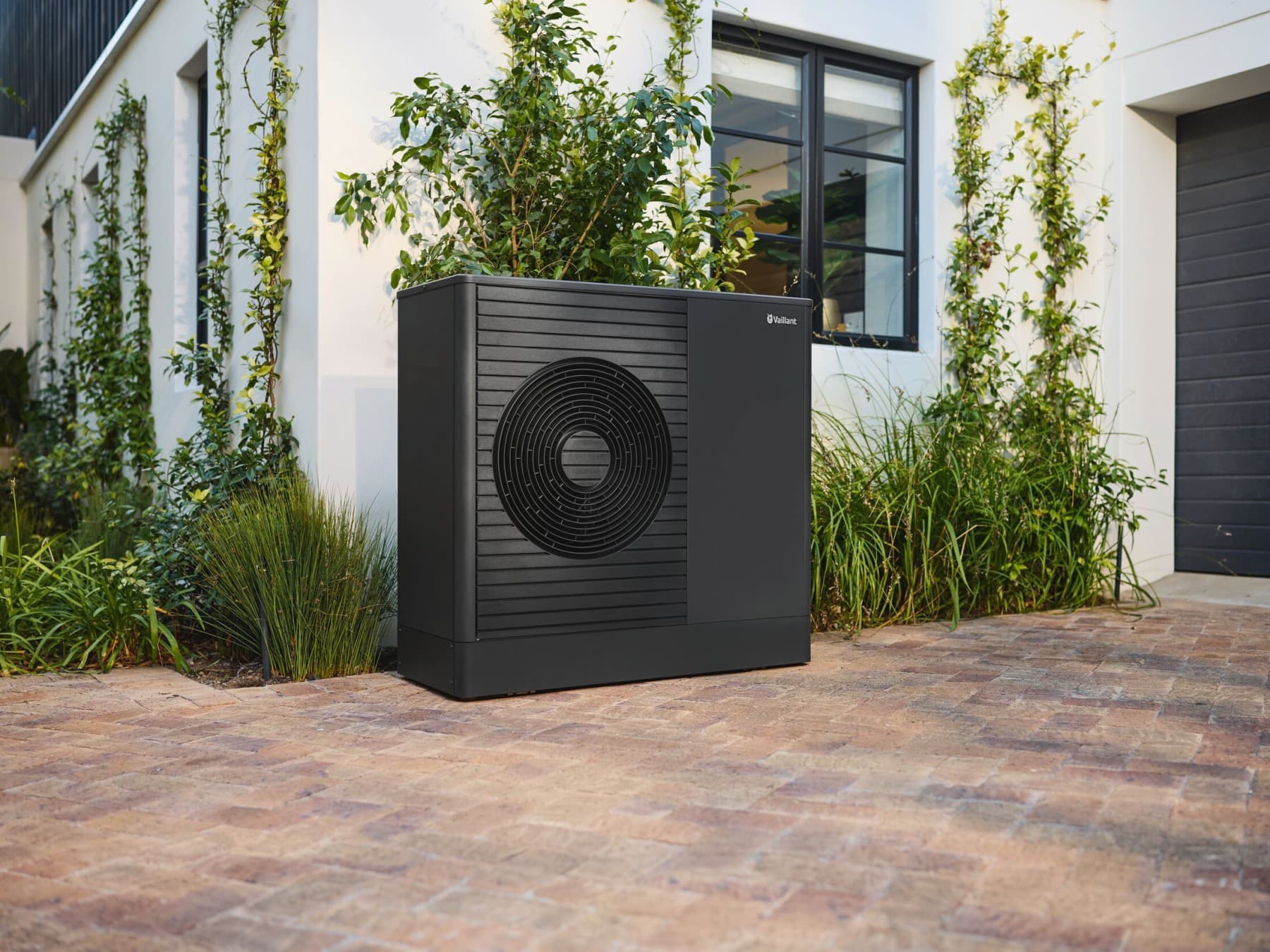 Pompe à chaleur anthracite aroTHERM plus devant la maison | Vaillant