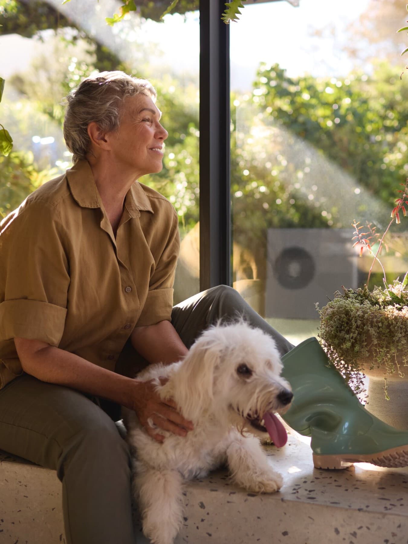 Une femme avec un chien devant une pompe à chaleur