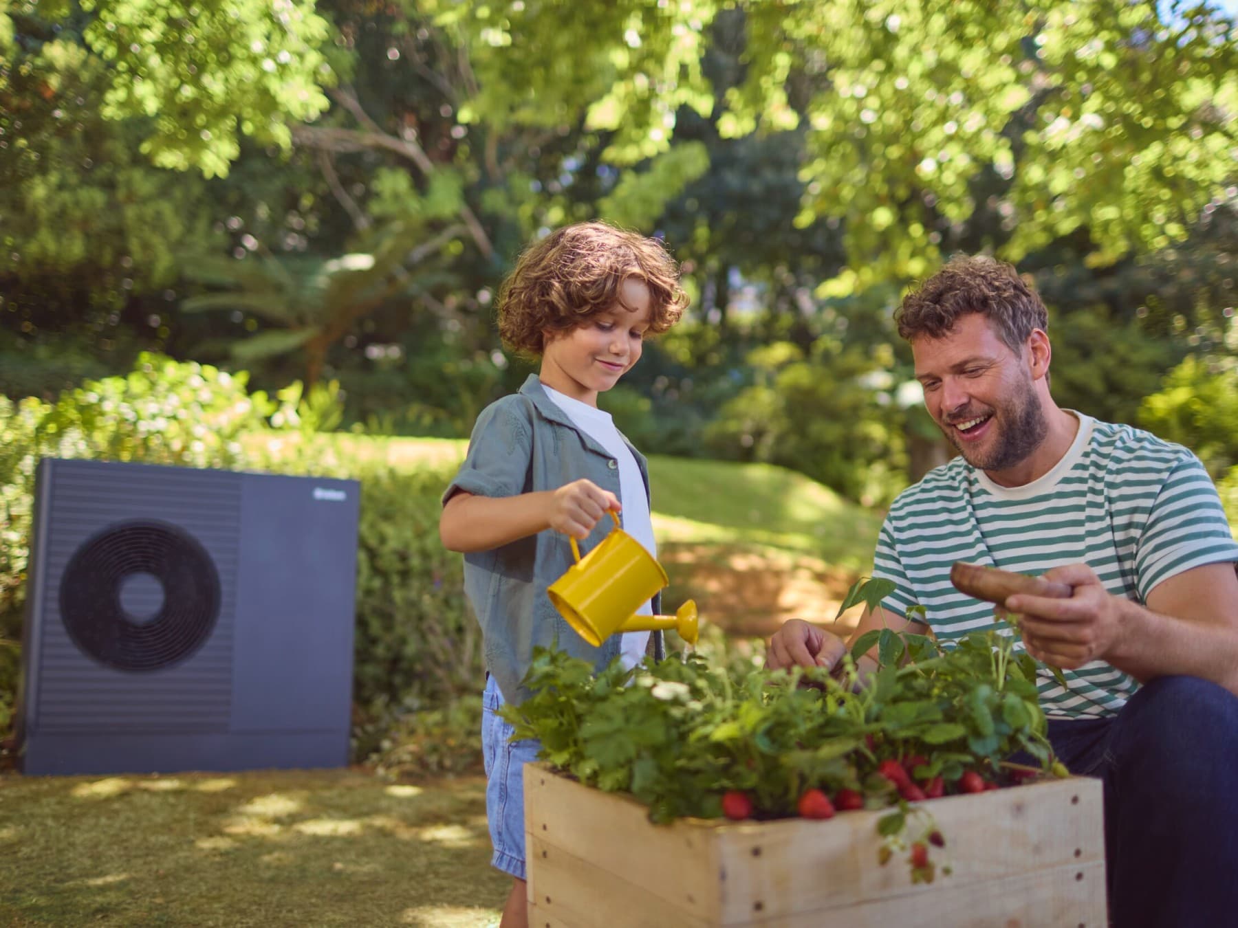 Un père et son fils jardine dans leur jardin | Vaillant