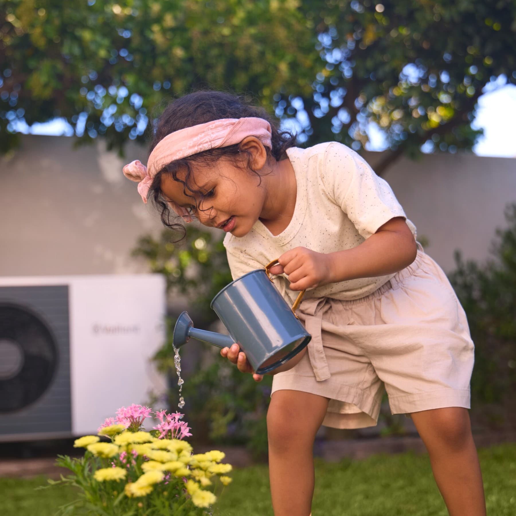Enfant arrosant des fleurs | Vaillant