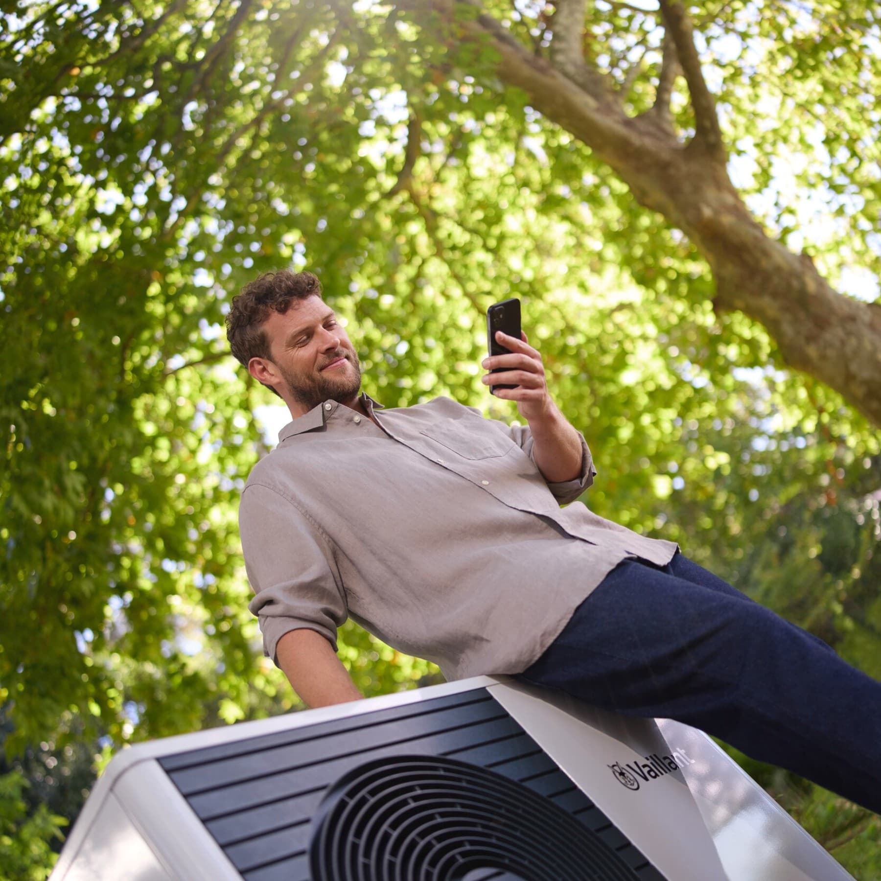 Un installateur et une femme devant une pompe à chaleur | Vaillant