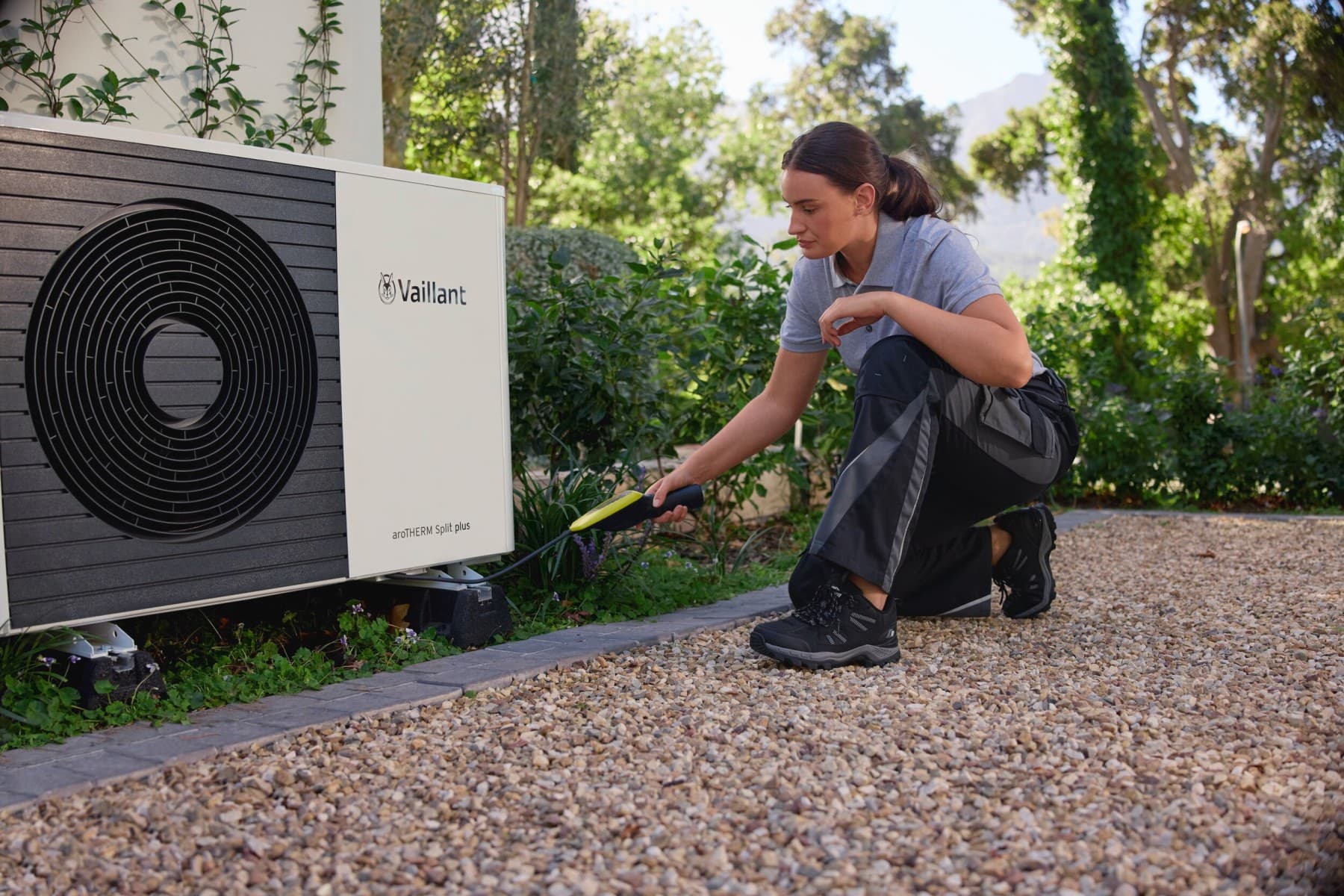 Installateur travaillant sur une pompe à chaleur extérieure | Vaillant